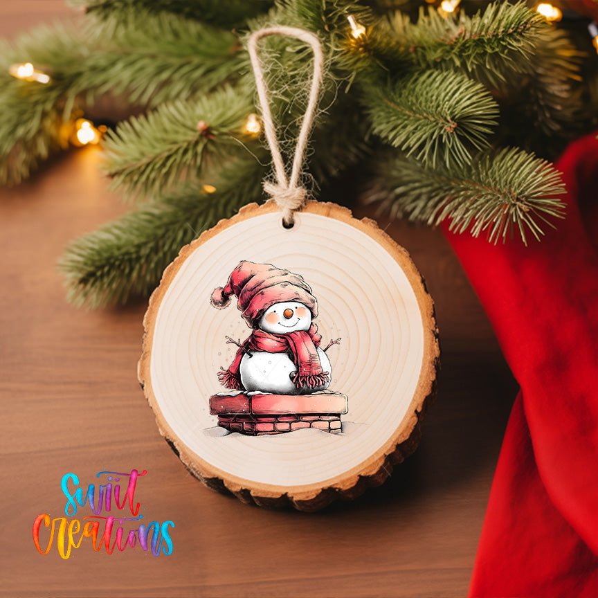 A wooden ornament featuring a snowman is hanging on a Christmas tree, surrounded by pine branches and twinkling lights.