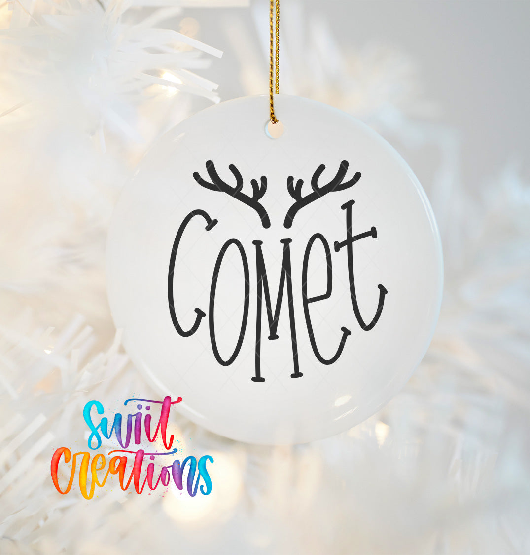A white ornament with the word "COMET" written on it, hanging on a string.
