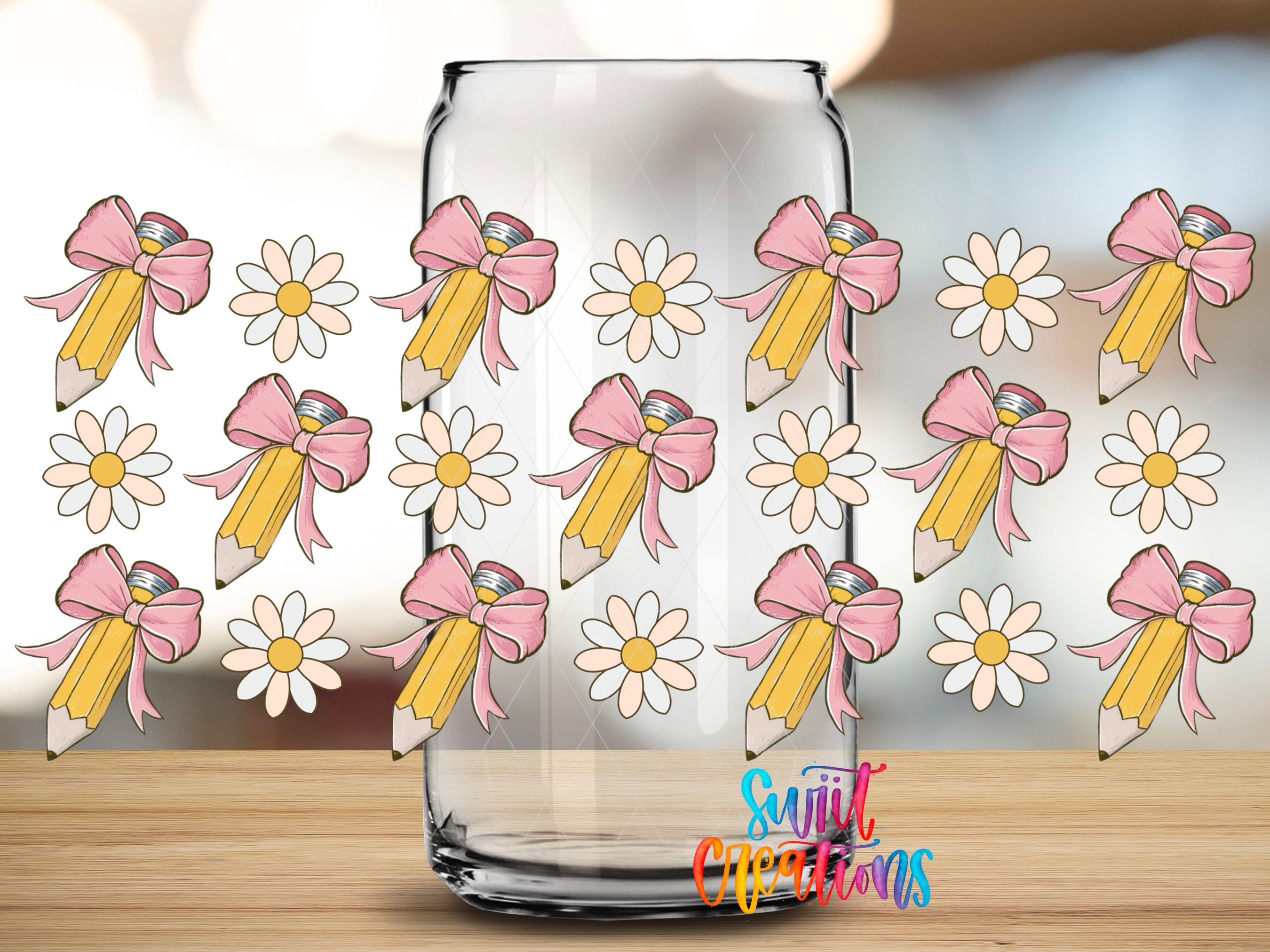 a clear glass jar with a repeating pattern of pink and yellow pencils with bows and white daisies on a wooden surface.