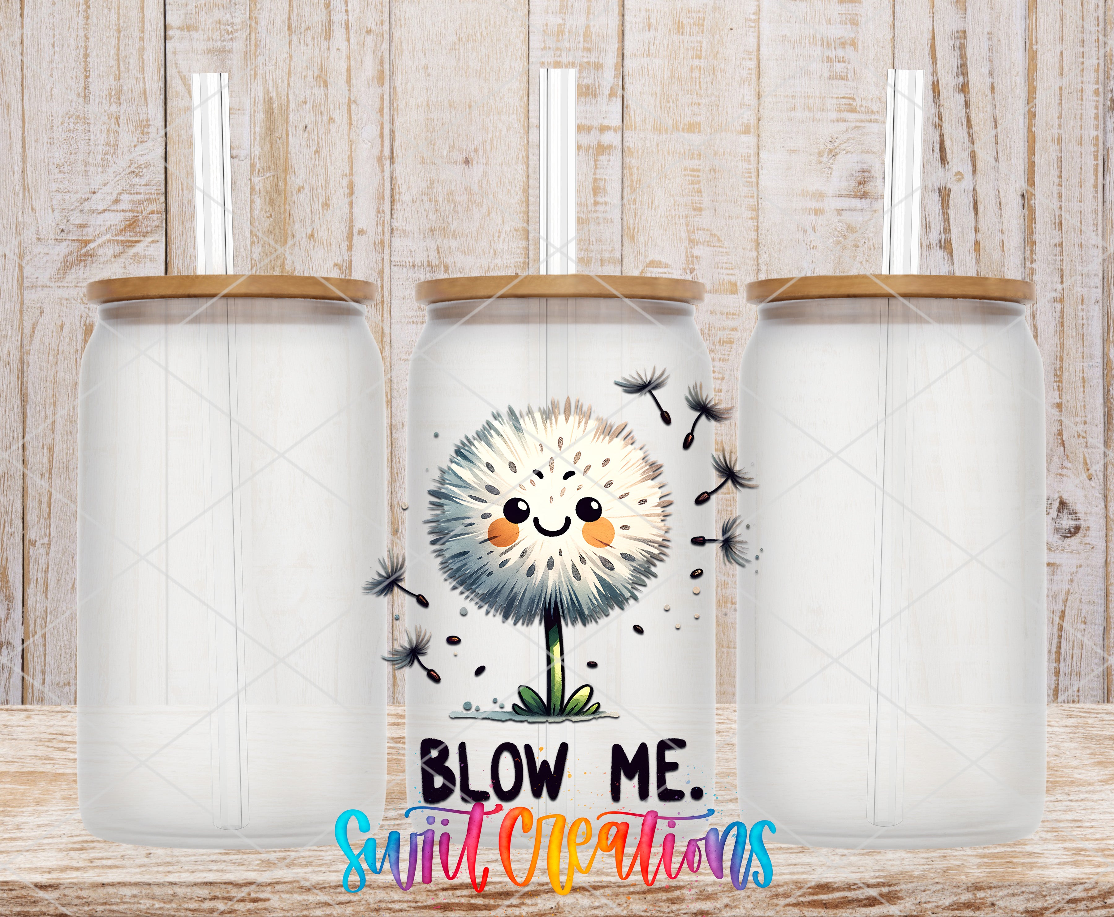 three clear glass tumblers with straws, each with a lid and a small cartoon dandelion design on the front. The text "BLOW ME. SUIT CREATIONS" is displayed in a colorful, playful font below the tumblers.