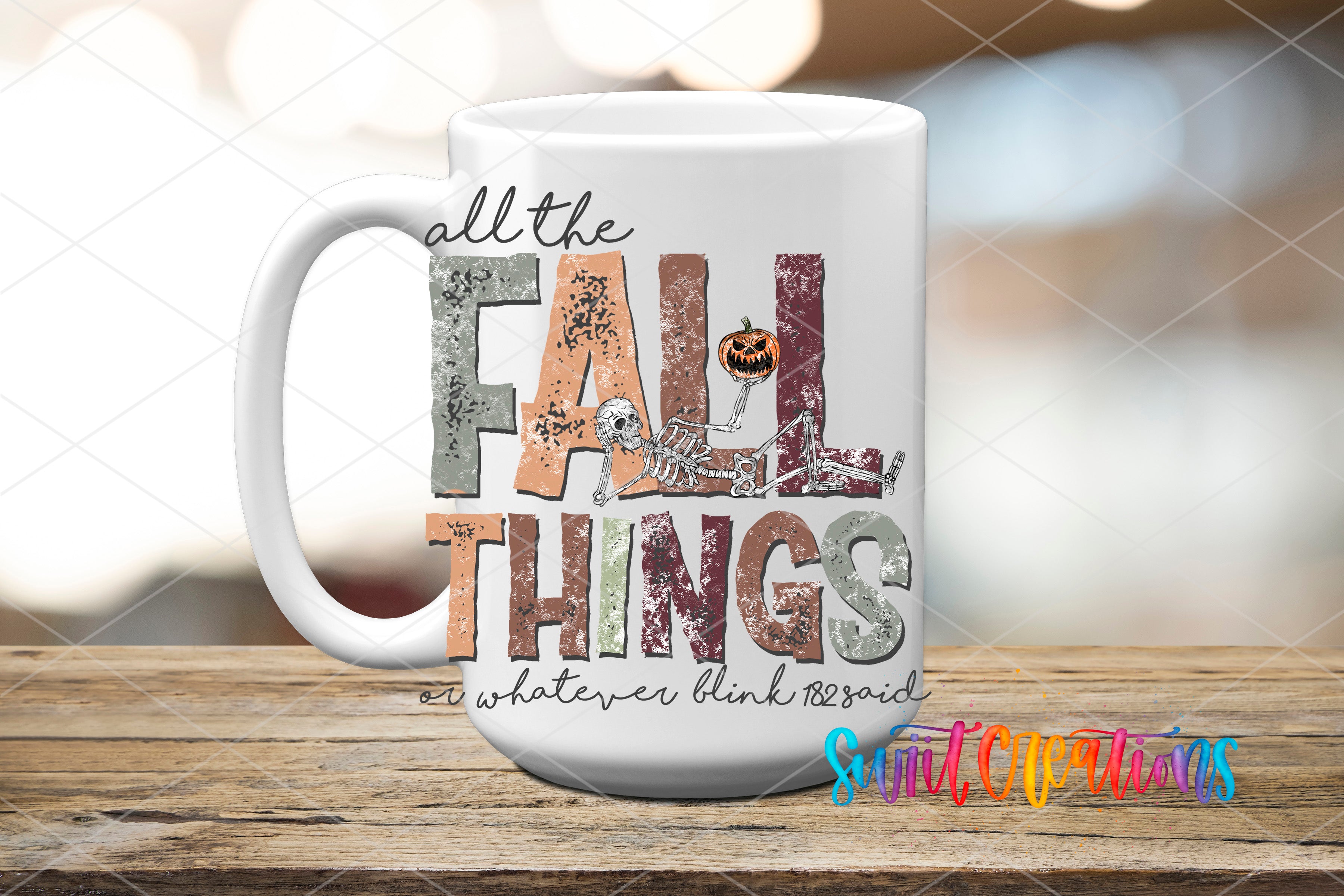 A white mug with the text "all the FALL THINGS" printed on it, along with a skeleton and pumpkin graphic.