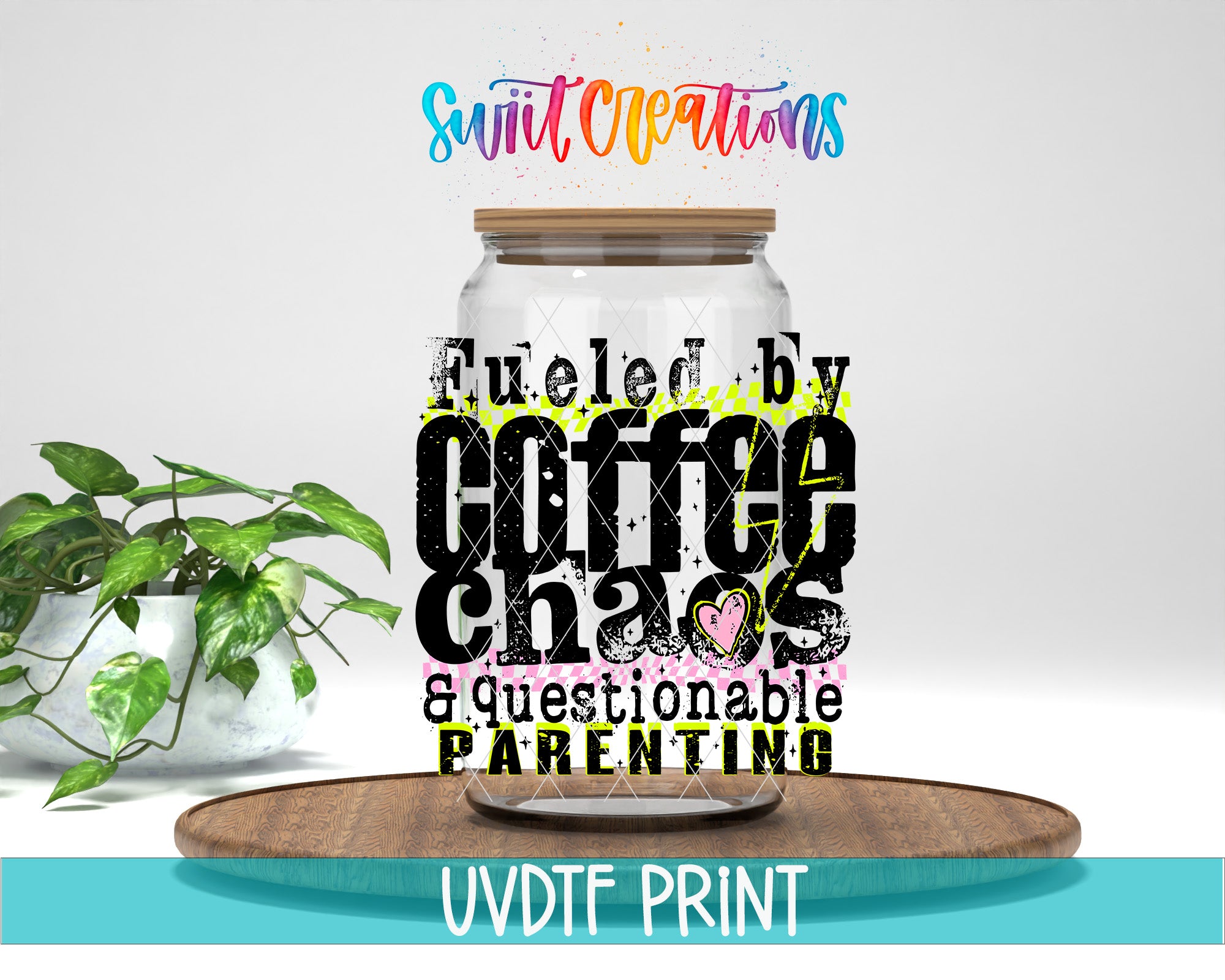 a large glass jar with a wooden lid, surrounded by a potted plant and a wooden tray. The jar has a colorful and artistic design, with text that reads "Fuelled by Coffee Chaos & questionable PARENTING".