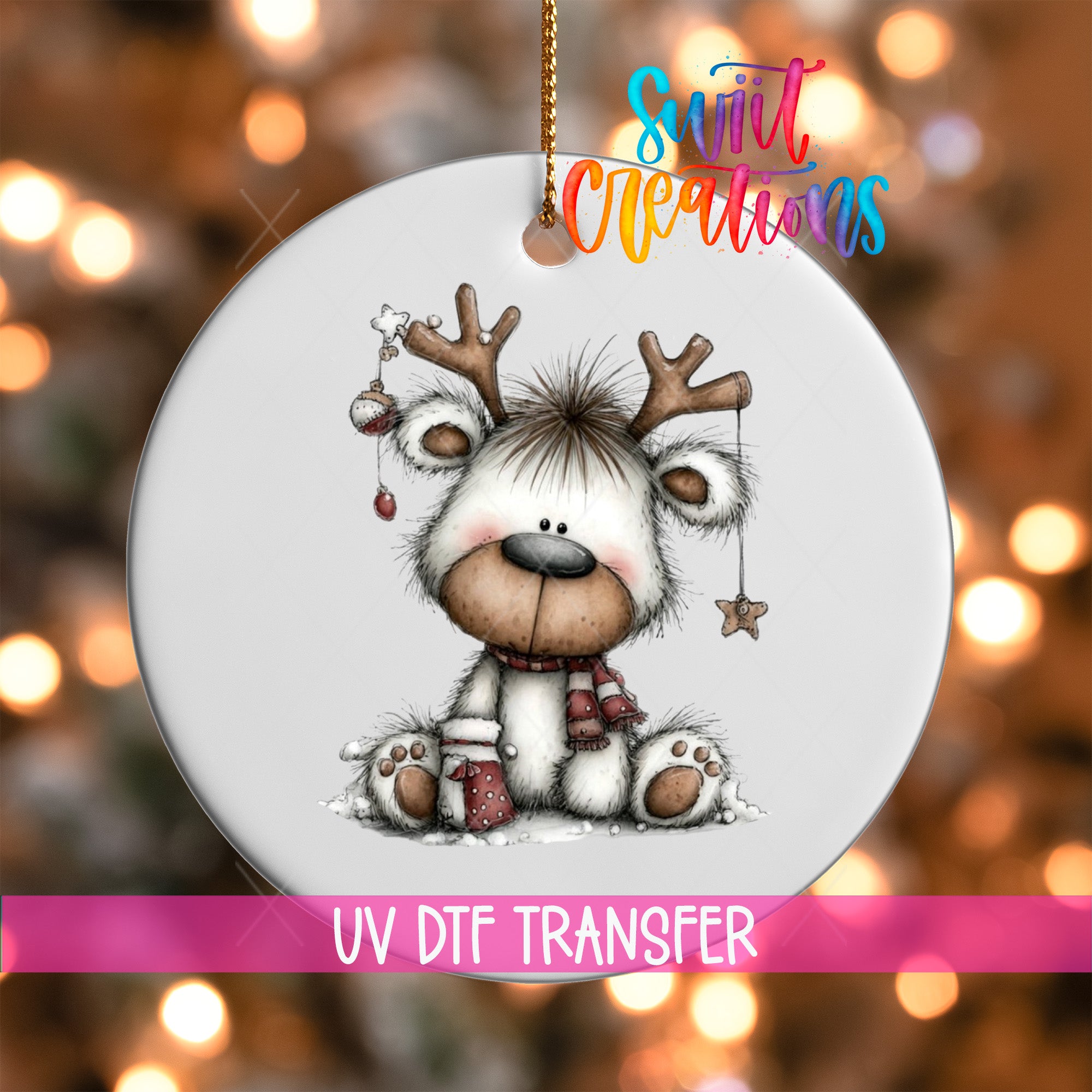 A white ornament with a cute reindeer design, featuring a star and a ribbon, is hanging against a background of colorful lights.