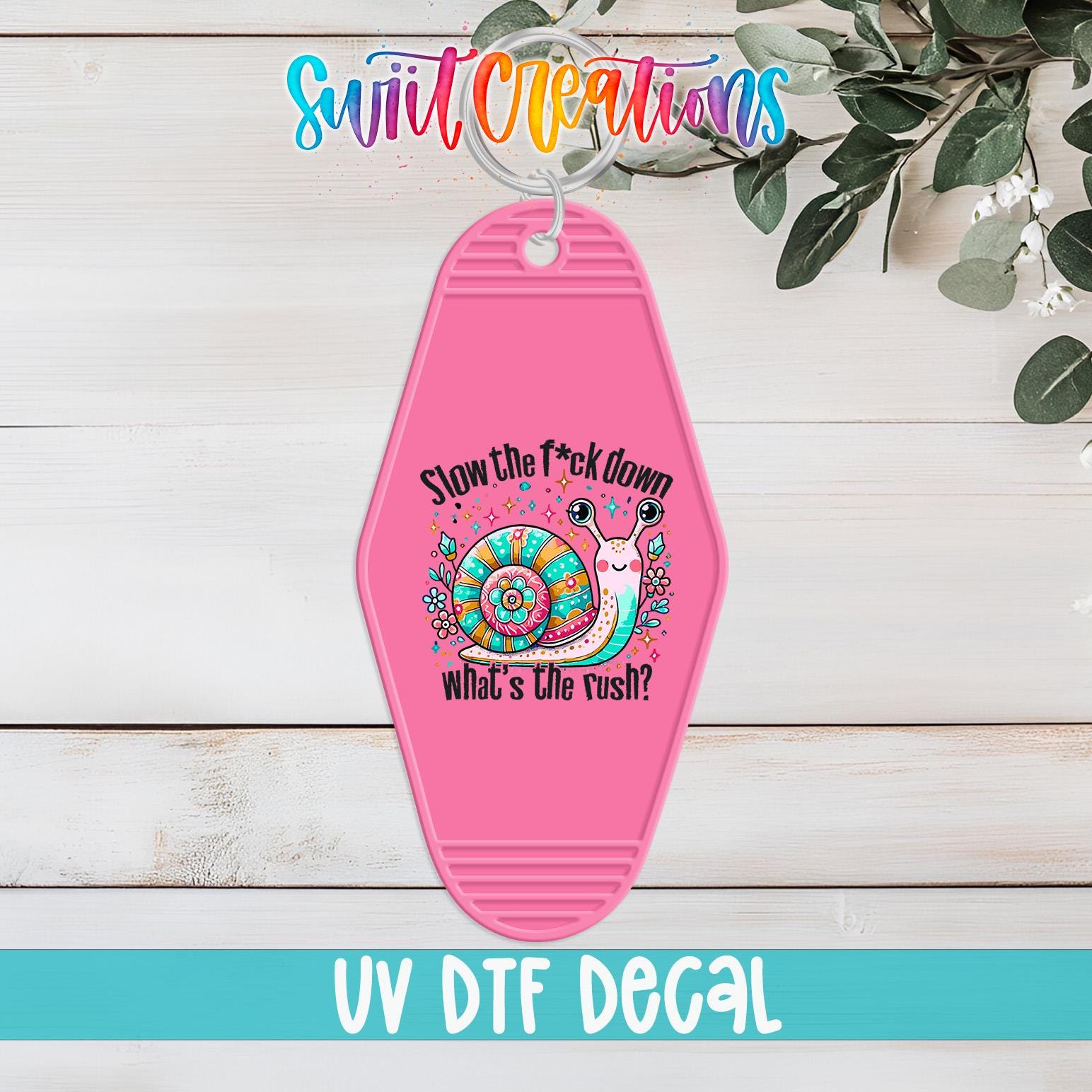 A pink keychain with a colorful snail design and text that says "Slow the fuck down what's the rush?"