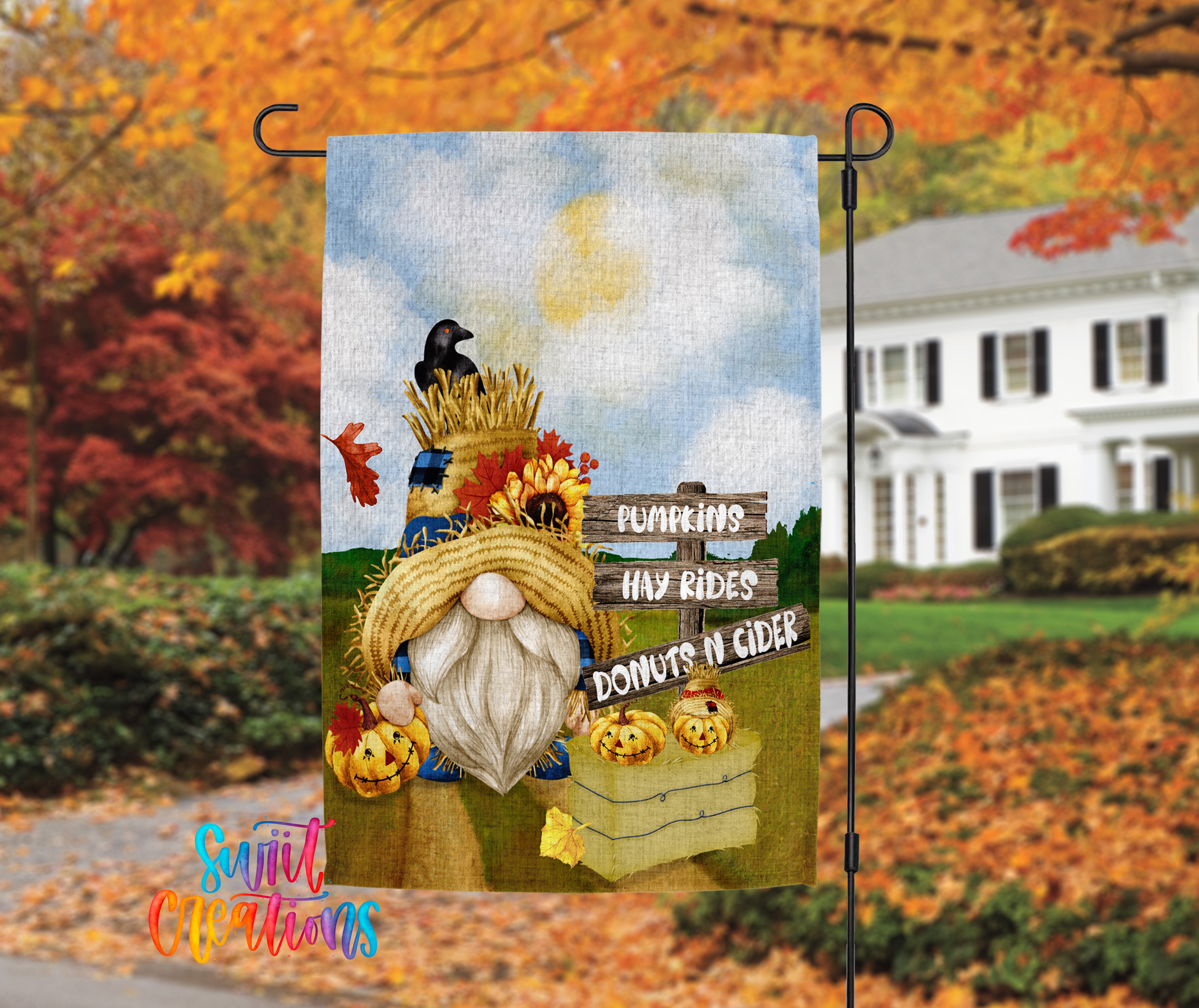 A banner featuring a gnome holding a sign that says "Pumpkins hay rides donuts n cider" against a backdrop of autumn foliage and a white house.
