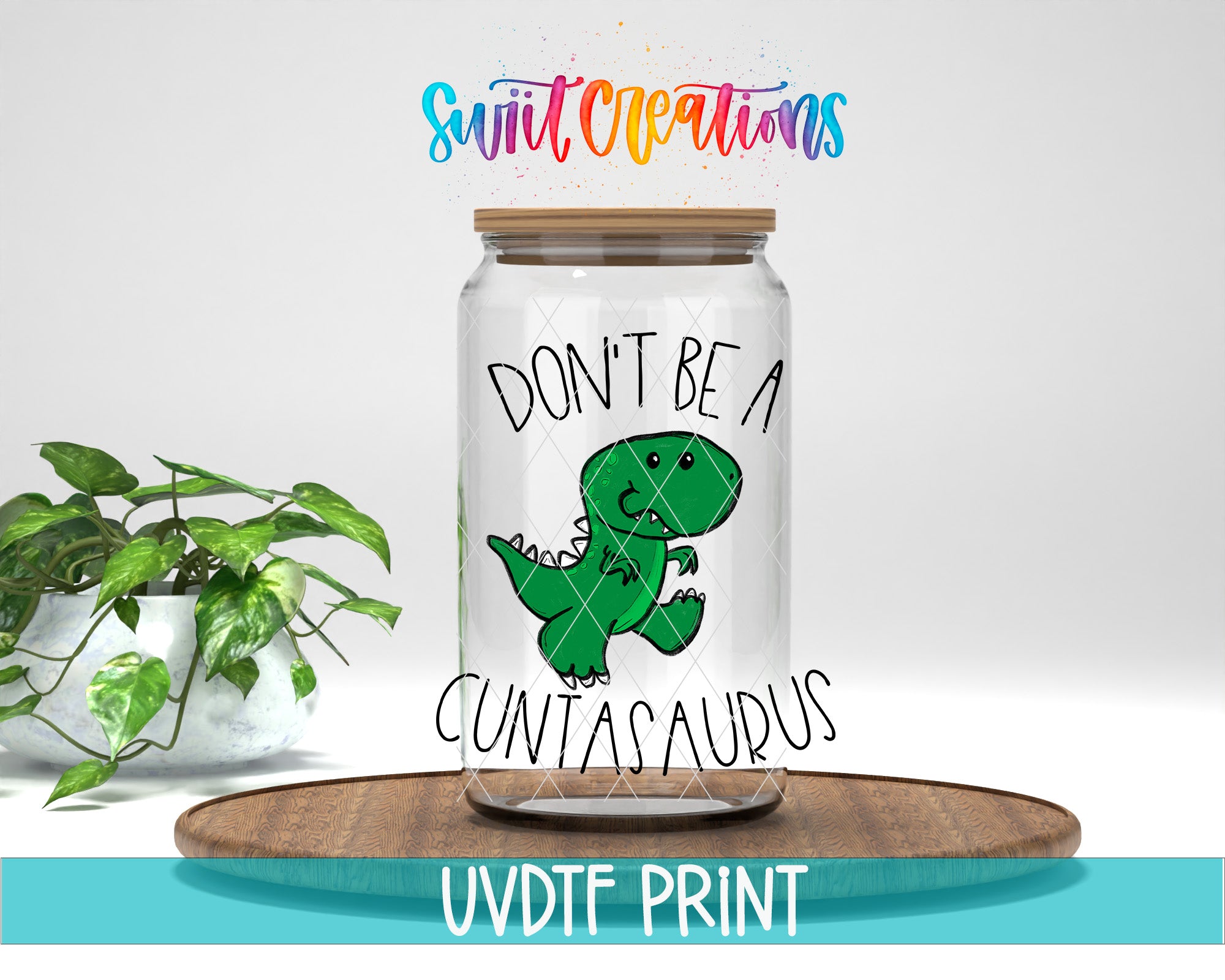 a glass jar with a cartoon dinosaur on it, along with the text "DON'T BE A CUNTASAURUS" printed on it. The jar is placed on a wooden surface, and there is a potted plant in the background.