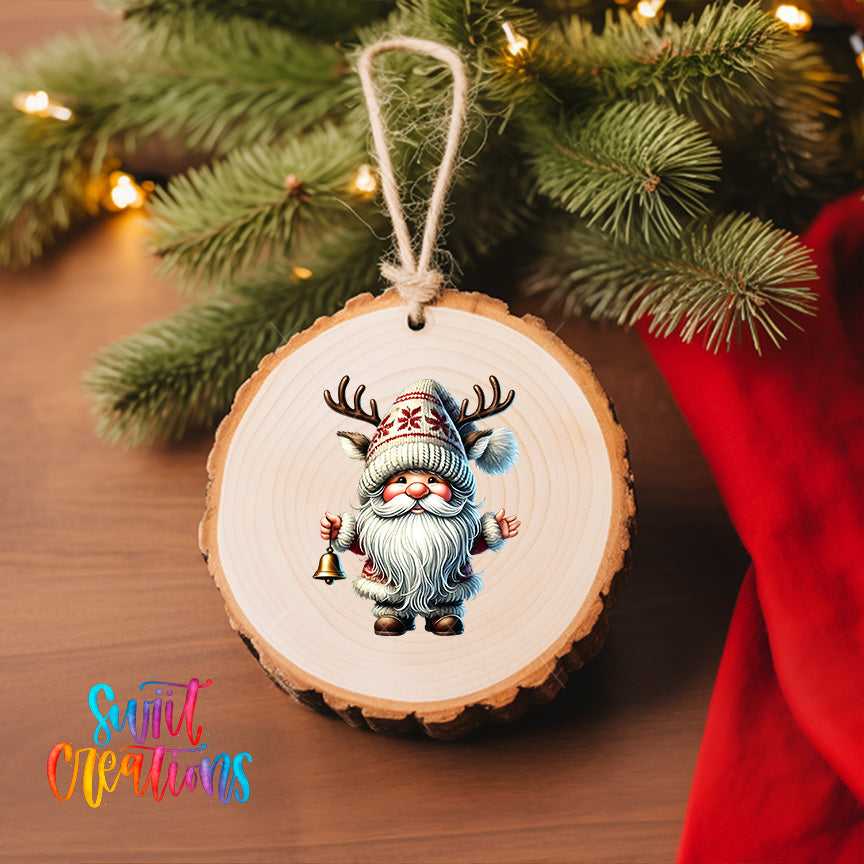 A wooden ornament featuring a gnome with antlers is hanging on a Christmas tree, surrounded by pine branches and twinkling lights.