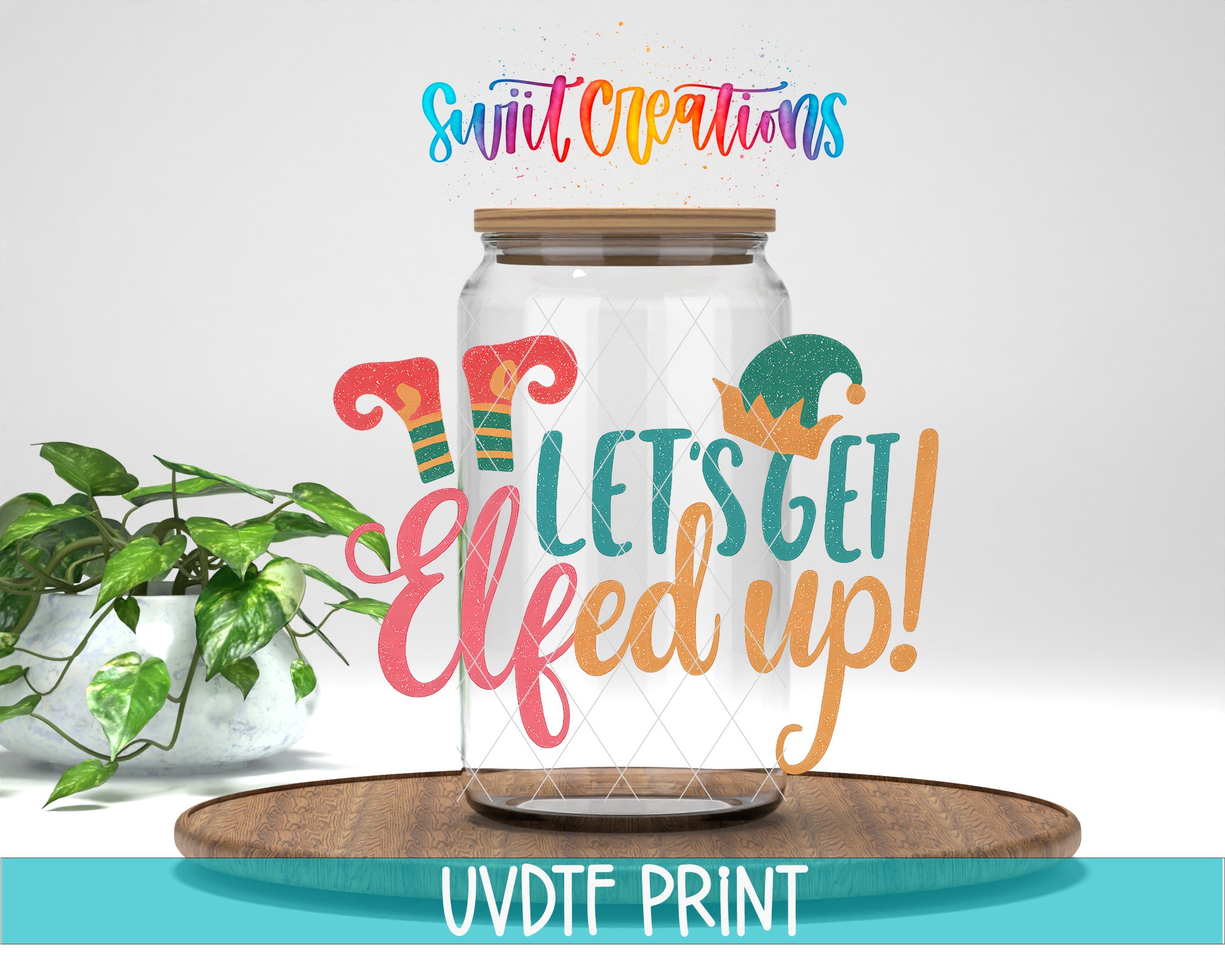 A glass jar with a lid, decorated with a whimsical elf design, sits on a wooden surface. The jar has a label that reads "Let's get Elfed up!" and the background is a plain white. There is also a plant and a wooden tray in the background.