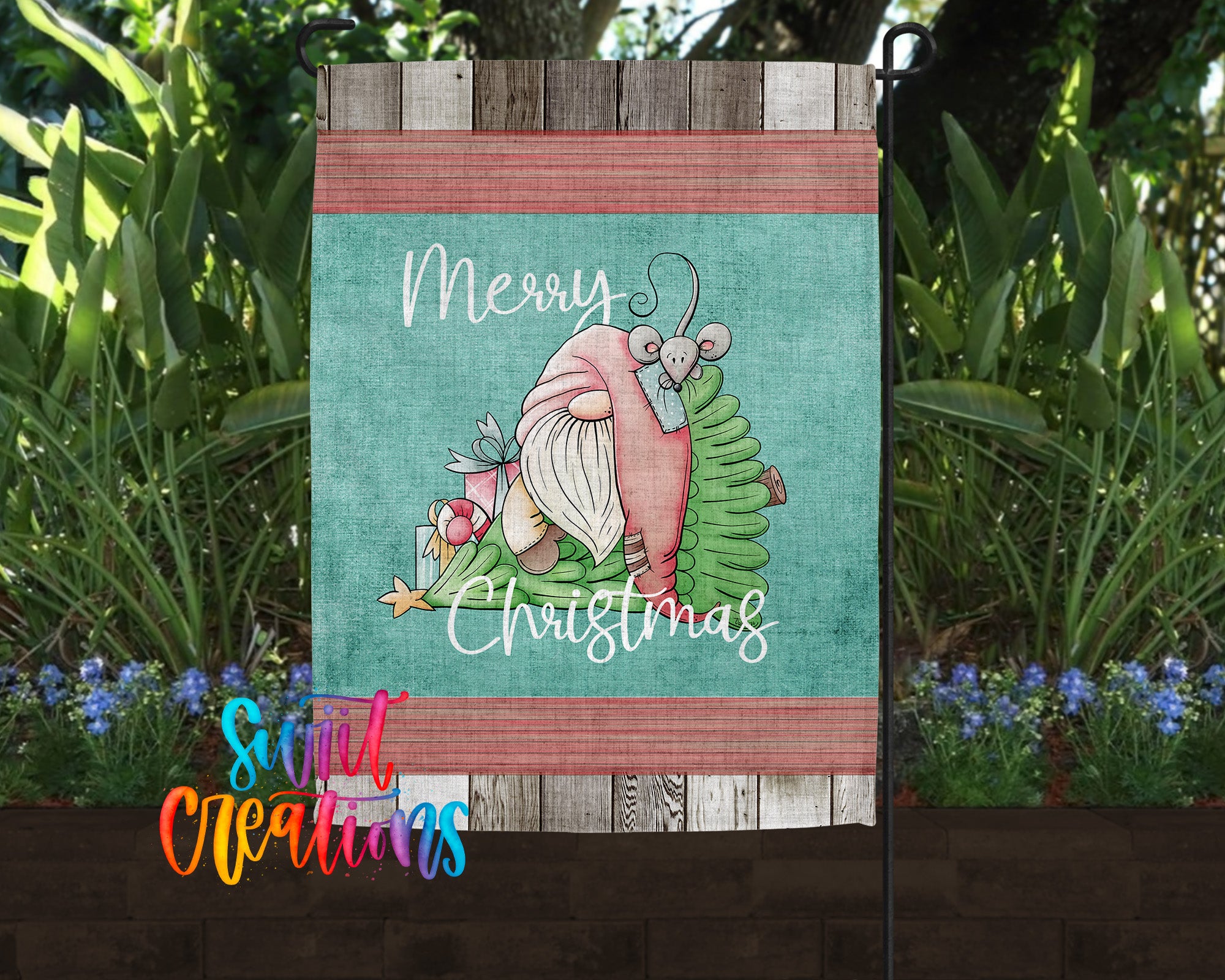 A colorful garden sign with a gnome and Christmas decorations, surrounded by lush greenery and flowers.