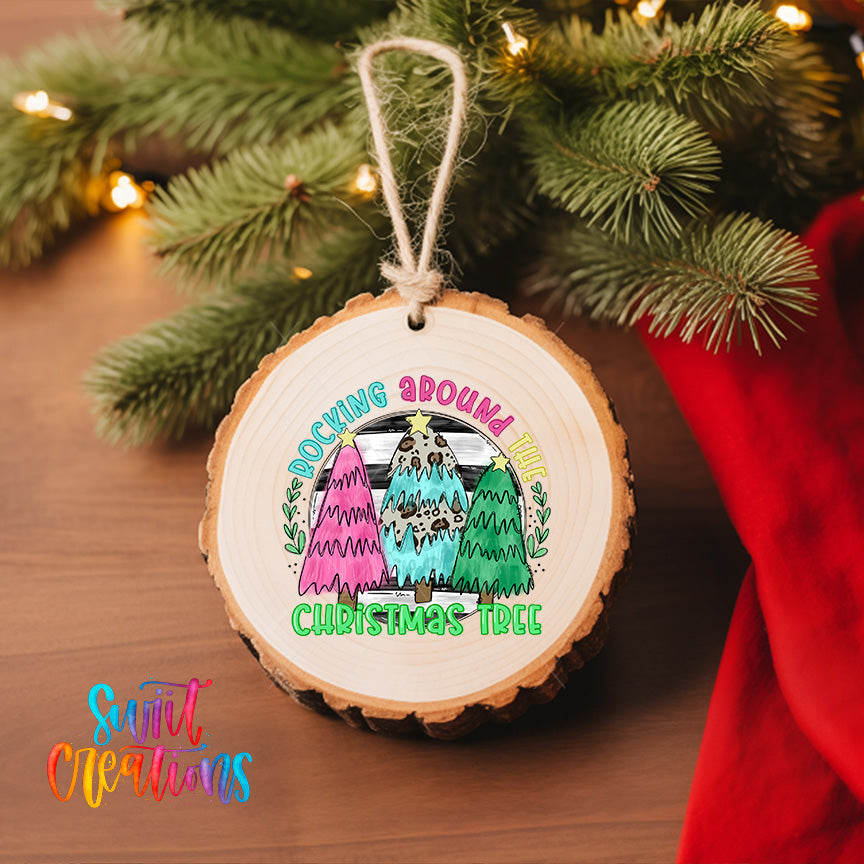 A wooden ornament with a colorful design hangs on a Christmas tree, surrounded by greenery and twinkling lights.