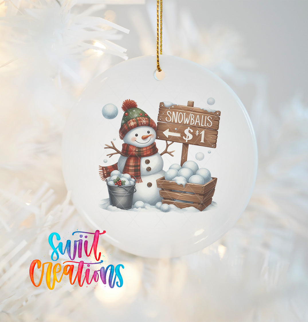 A snowman ornament with a sign that says "Snowballs $1" hanging on a Christmas tree.