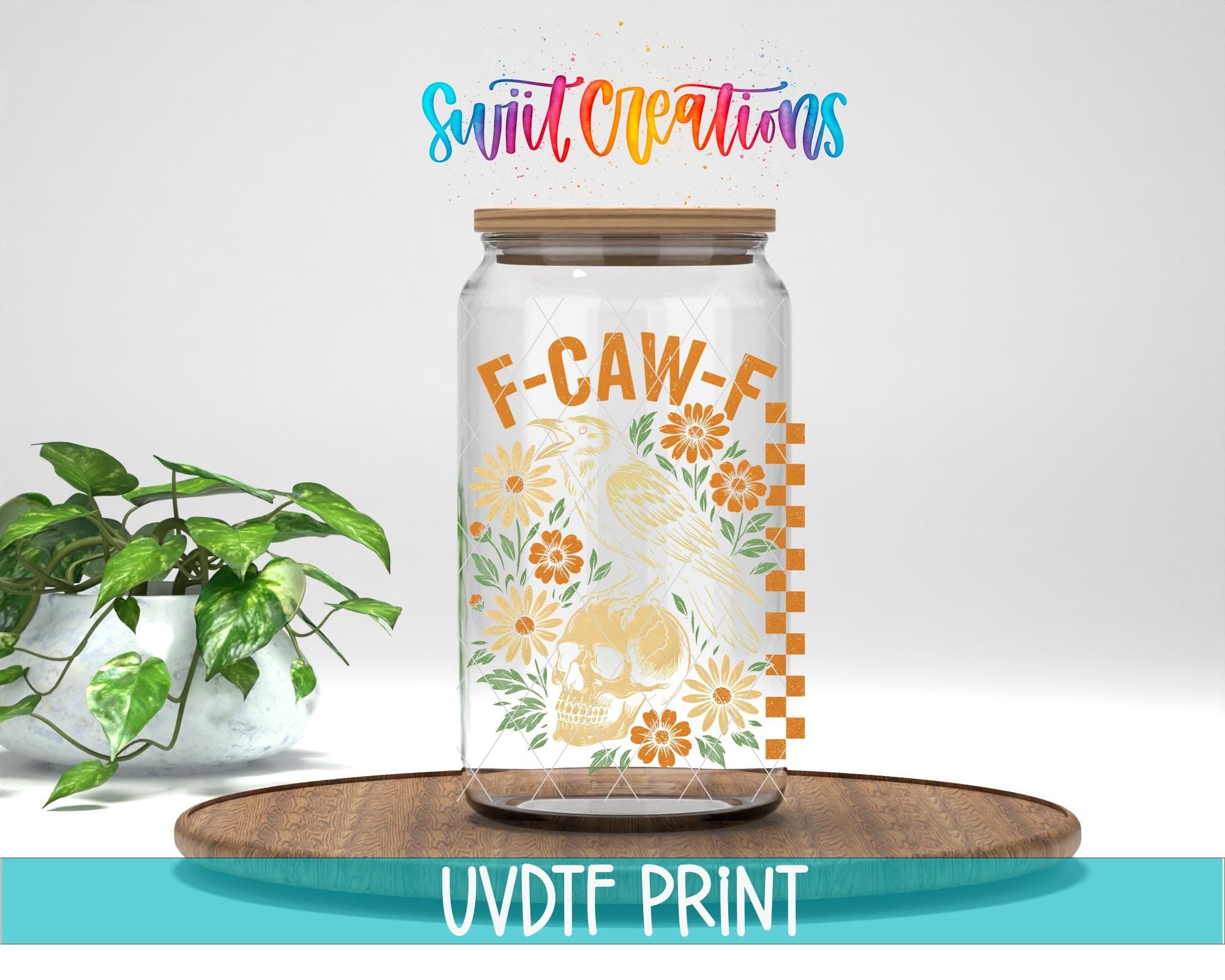 a glass jar with a label that reads "F-CAW-F" and has a skull and floral design. The jar is placed on a wooden surface, and there is a potted plant nearby. The text "Swift Creations" is written above the jar, and "UVDF PRINT" is written at the bottom of the image.