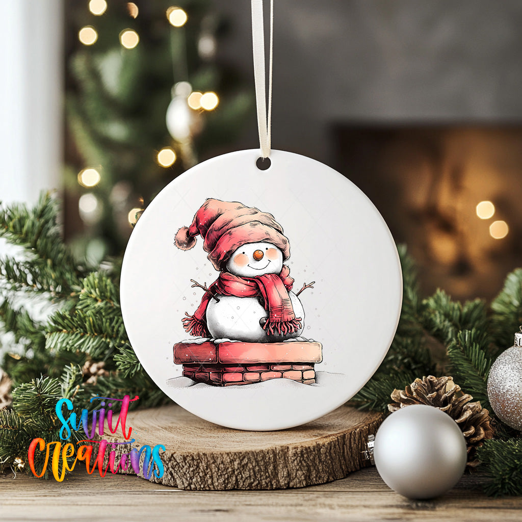 A white ceramic ornament featuring a snowman sitting on a brick chimney, surrounded by Christmas decorations and greenery.