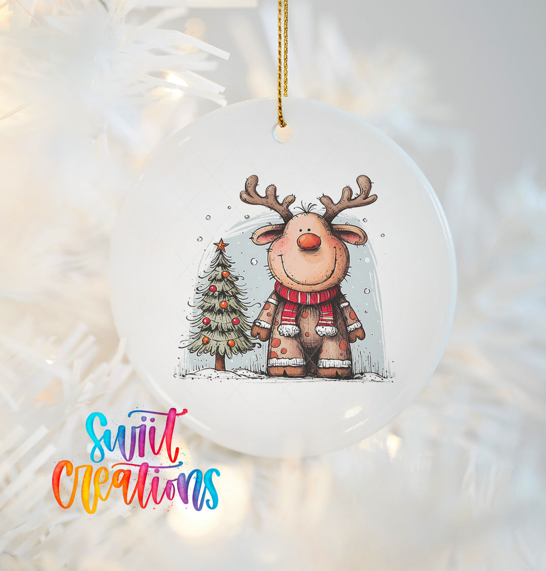 A white Christmas ornament featuring a cartoon reindeer with antlers and a small Christmas tree.