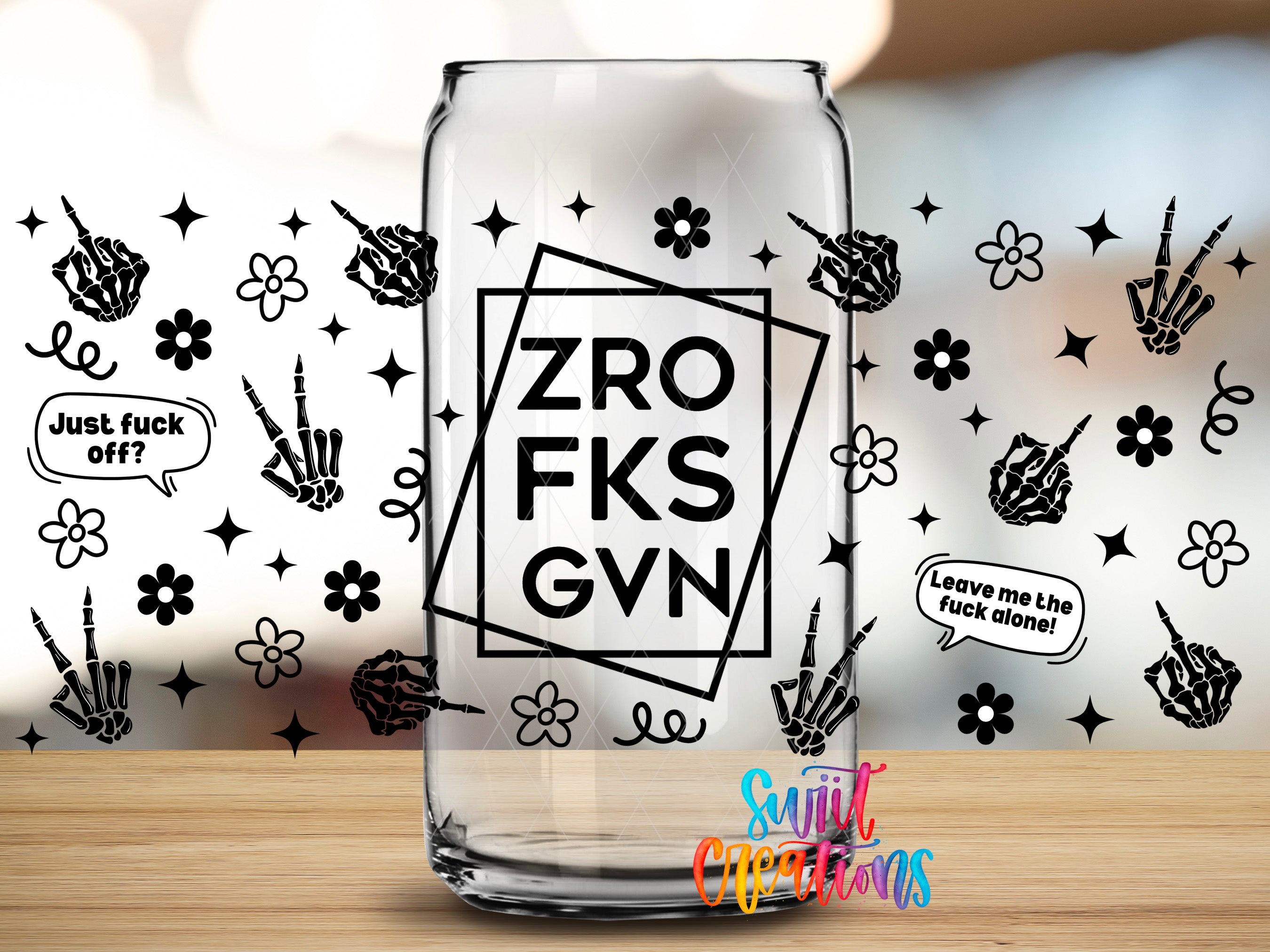 a clear glass can with various black and white designs and text on it, including skeletal hands, flowers, and speech bubbles.