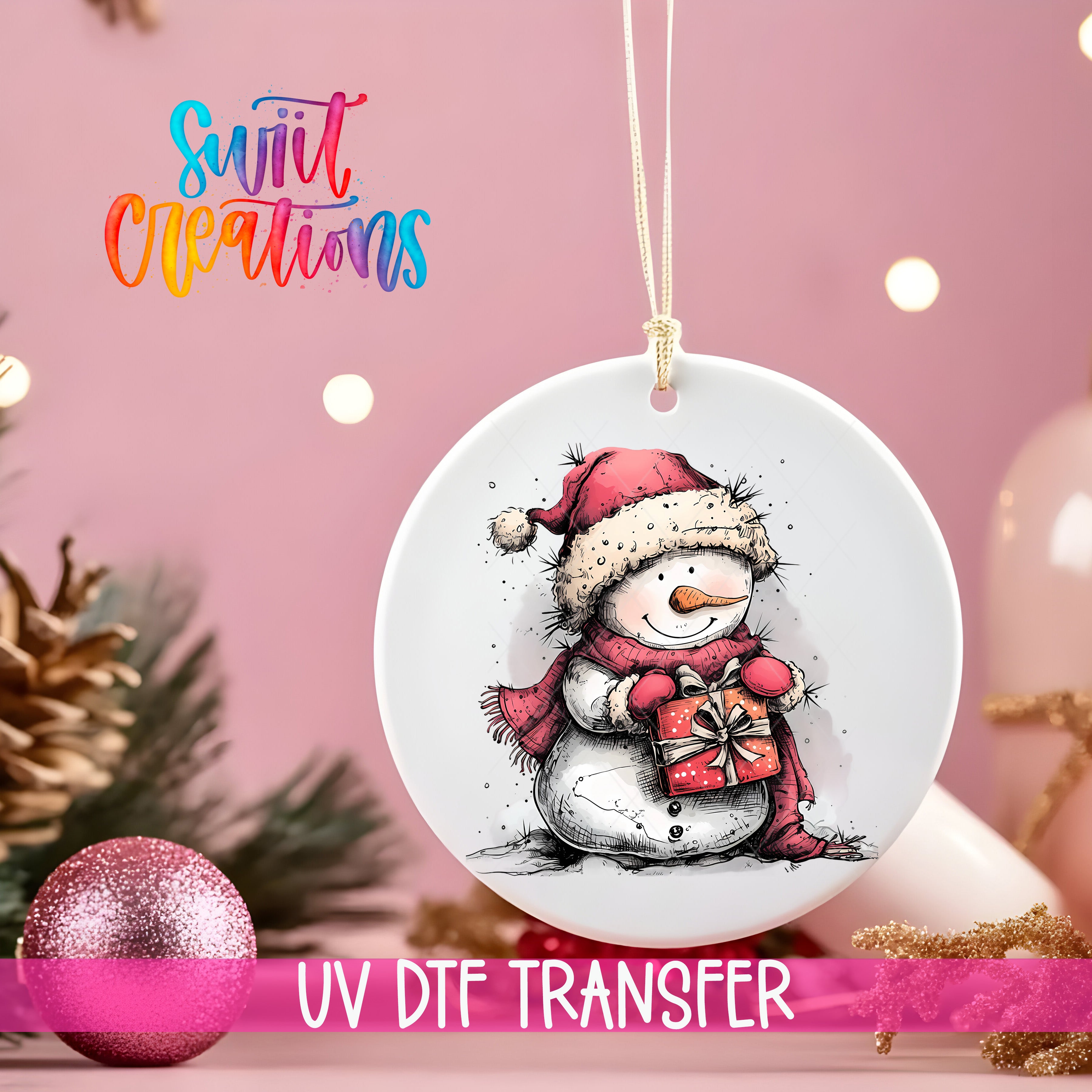 A white ornament with a snowman and a gift, hanging on a string against a pink background with Christmas decorations in the background.