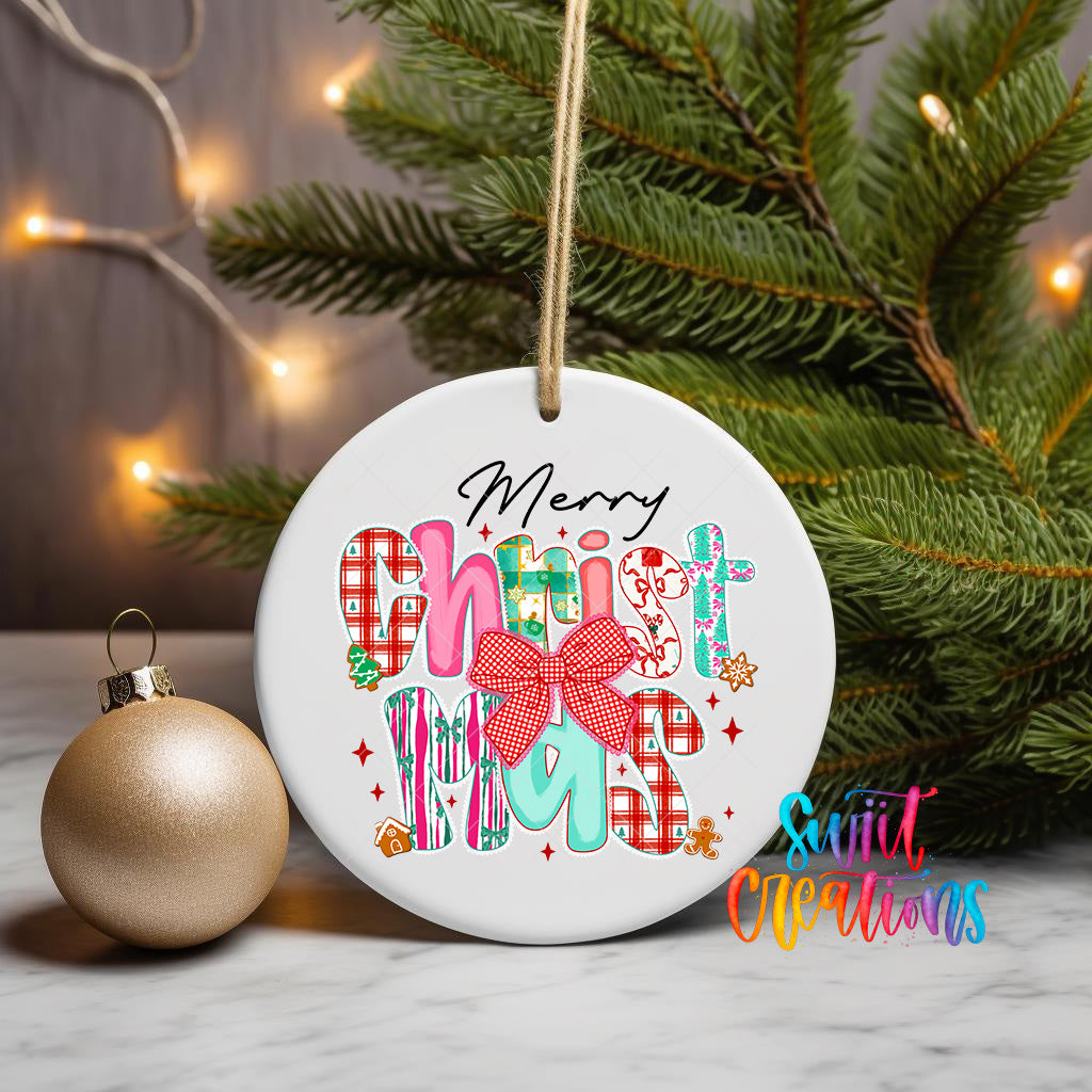 A white Christmas ornament with the text "Merry Christmas" written on it, hanging on a tree branch with a gold ornament next to it.