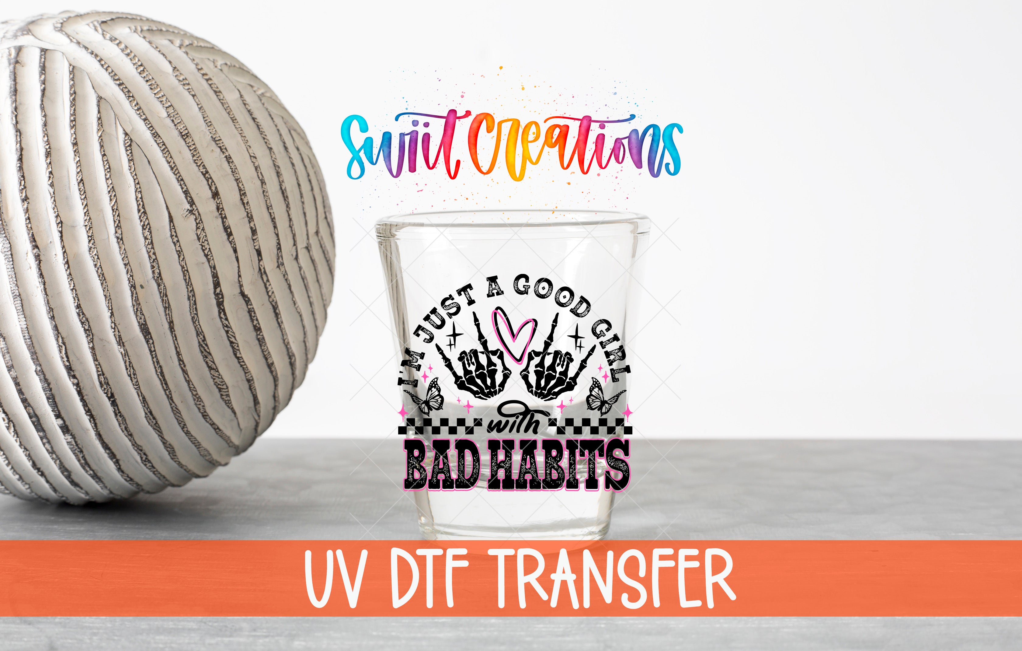 a glass with a hand-drawn design and text, along with a white ball and a rainbow-colored text overlay.