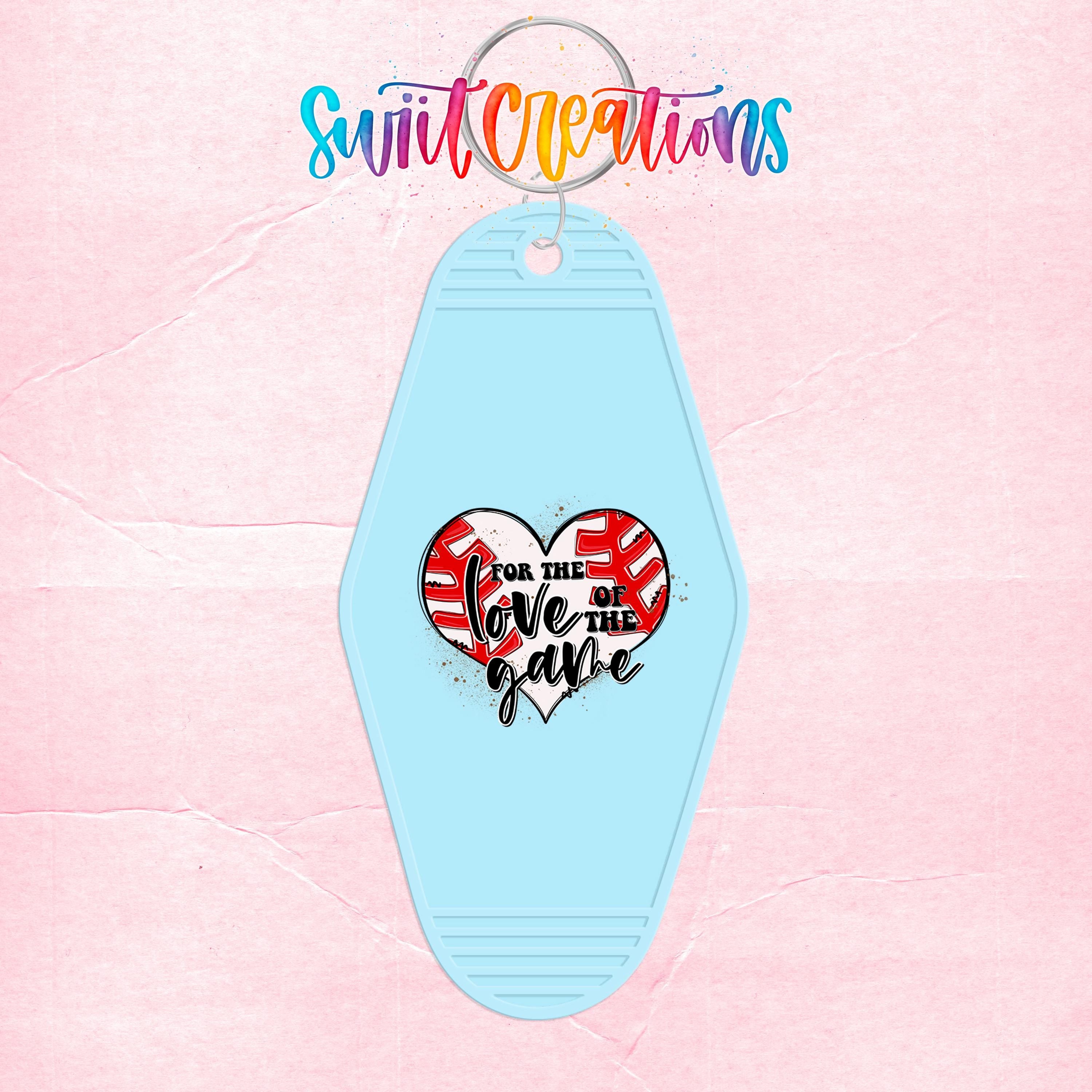 A light blue keychain with a heart-shaped design and text that says "I love the game".