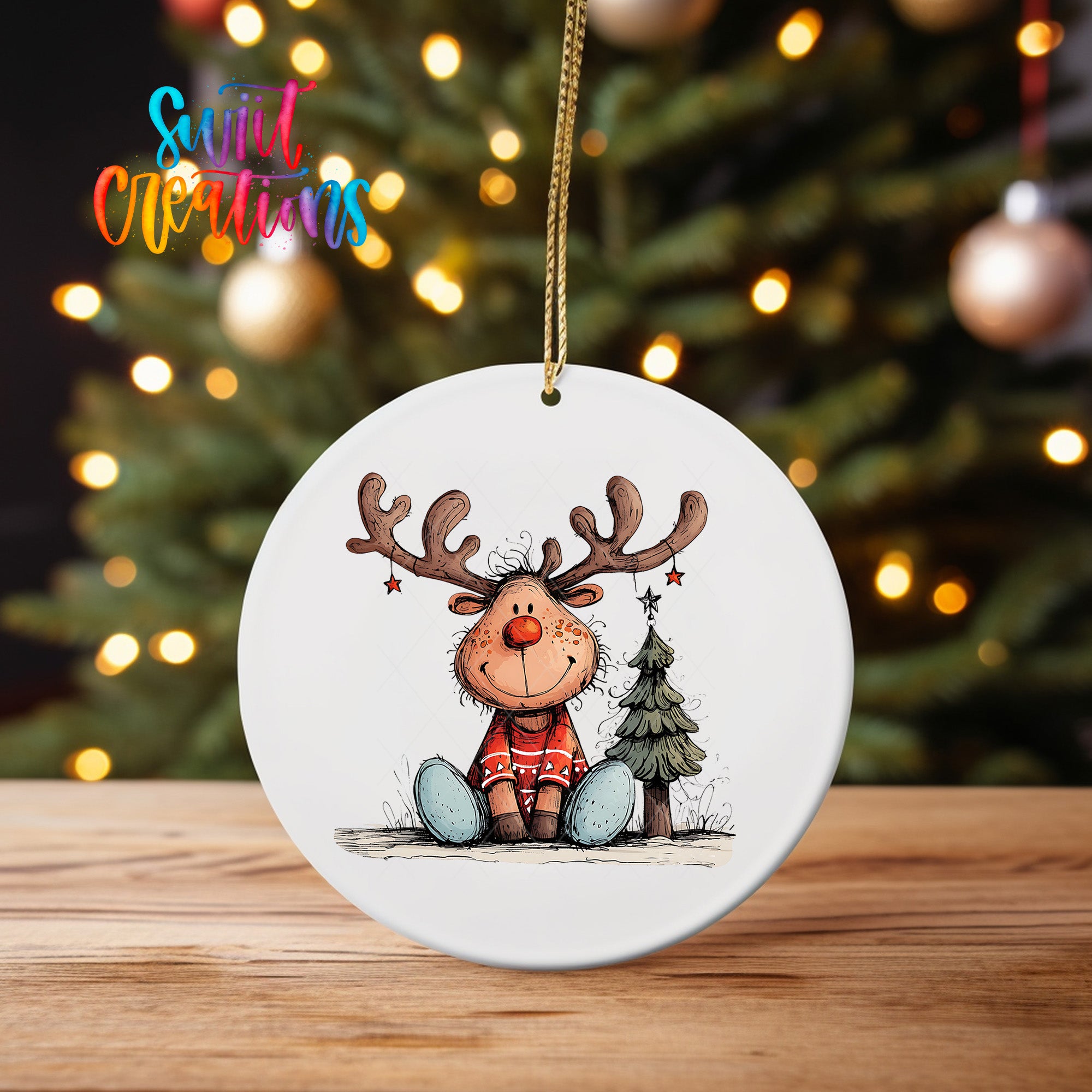 A white ornament featuring a cartoon reindeer sitting next to a Christmas tree, with a star above its head.