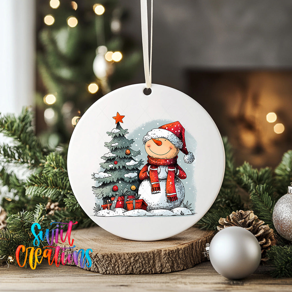 A white ceramic ornament featuring a snowman and a Christmas tree, surrounded by pine cones and ornaments, with a star on top of the tree.