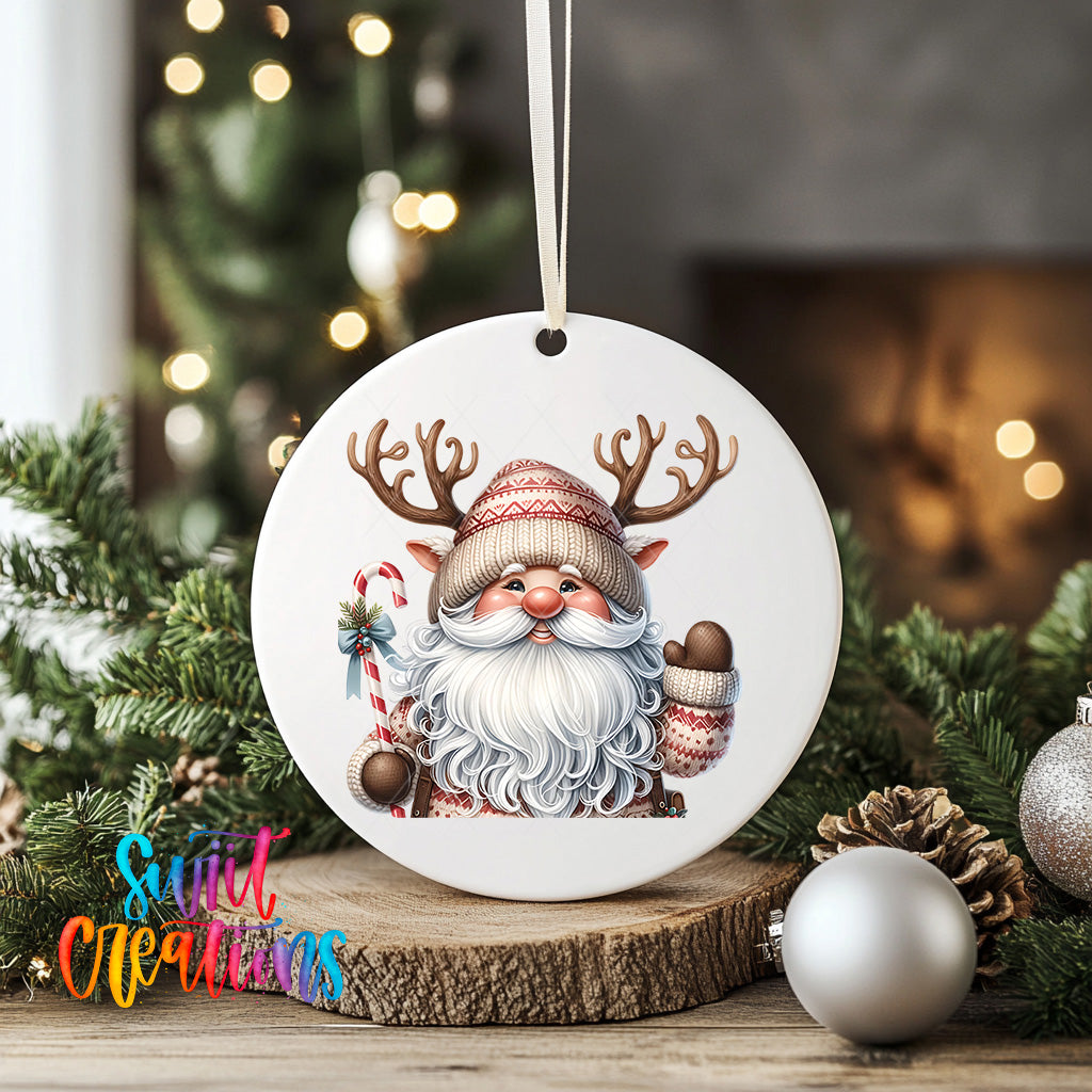 A white ornament featuring a smiling Santa Claus with antlers, surrounded by Christmas decorations such as pine cones and ornaments.