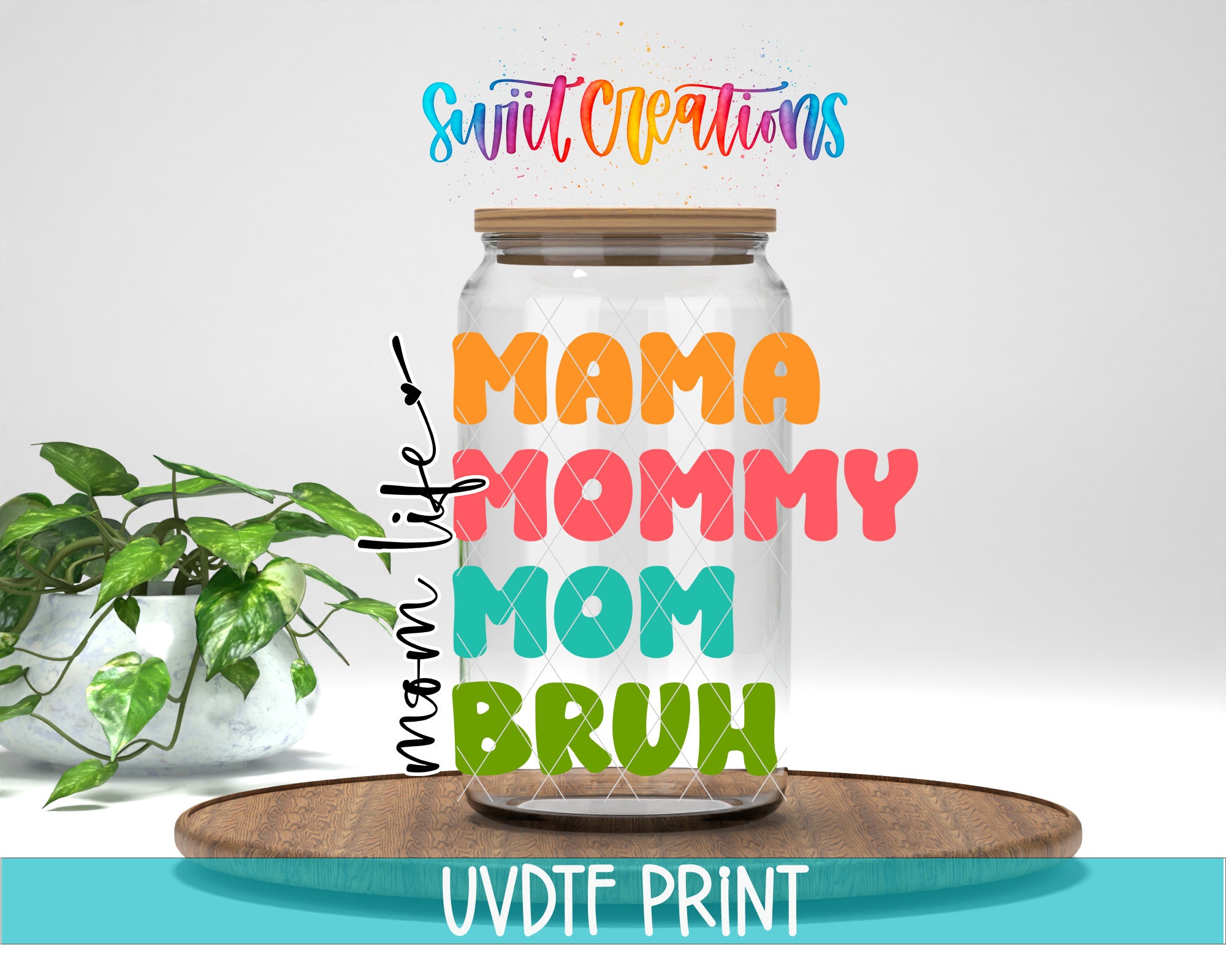 a glass jar with colorful text on it, placed on a wooden surface. There is a potted plant in the background.