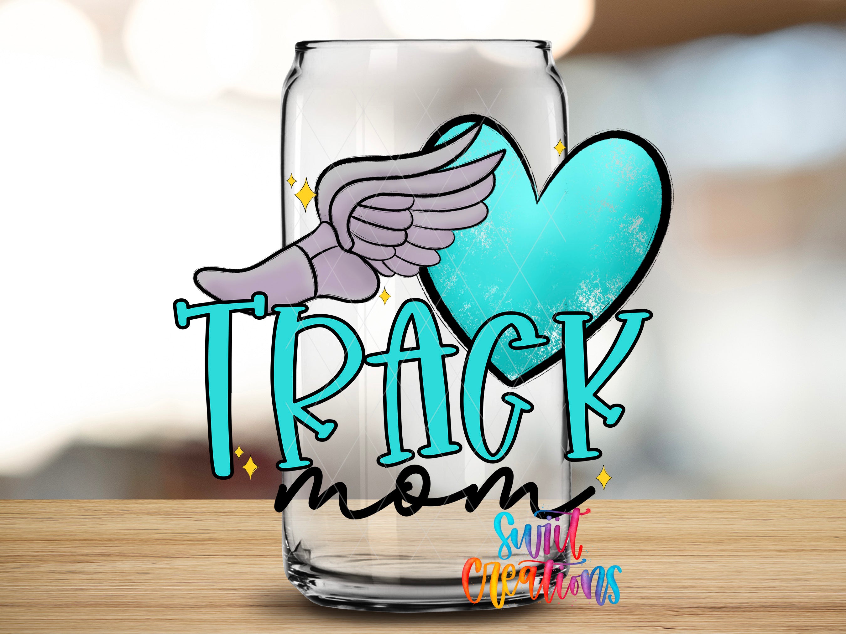 A glass can with a graphic design featuring a winged figure and a heart shape, along with the text "TRACK mom" and "Suntory creations" written on it.
