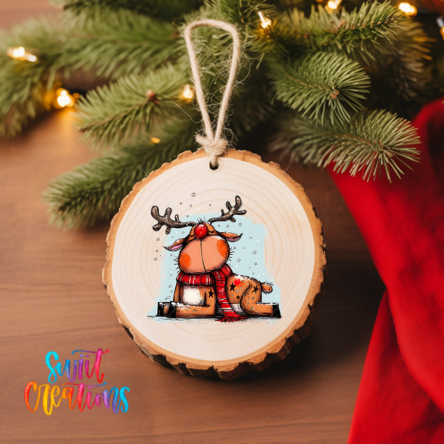 A wooden ornament featuring a cartoon reindeer with antlers and a red scarf, hanging on a Christmas tree.