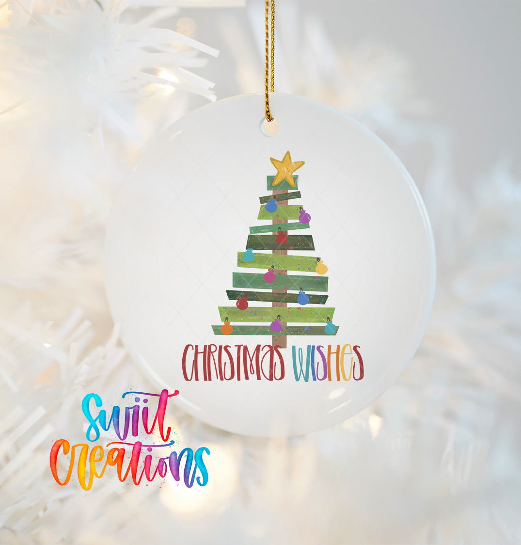 A white Christmas ornament with a colorful tree design and the text "Christmas Wishes" hanging on a string.