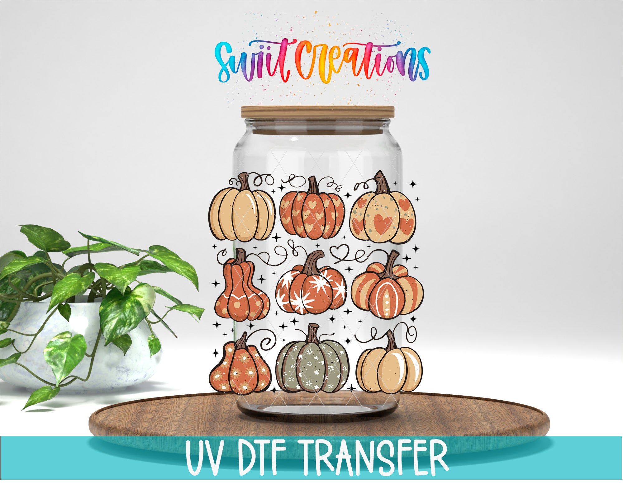 a glass jar with a variety of pumpkins and leaves on it, placed on a wooden surface. The jar is surrounded by a potted plant, and there is text at the bottom of the image that says "UV DFT Transfer".