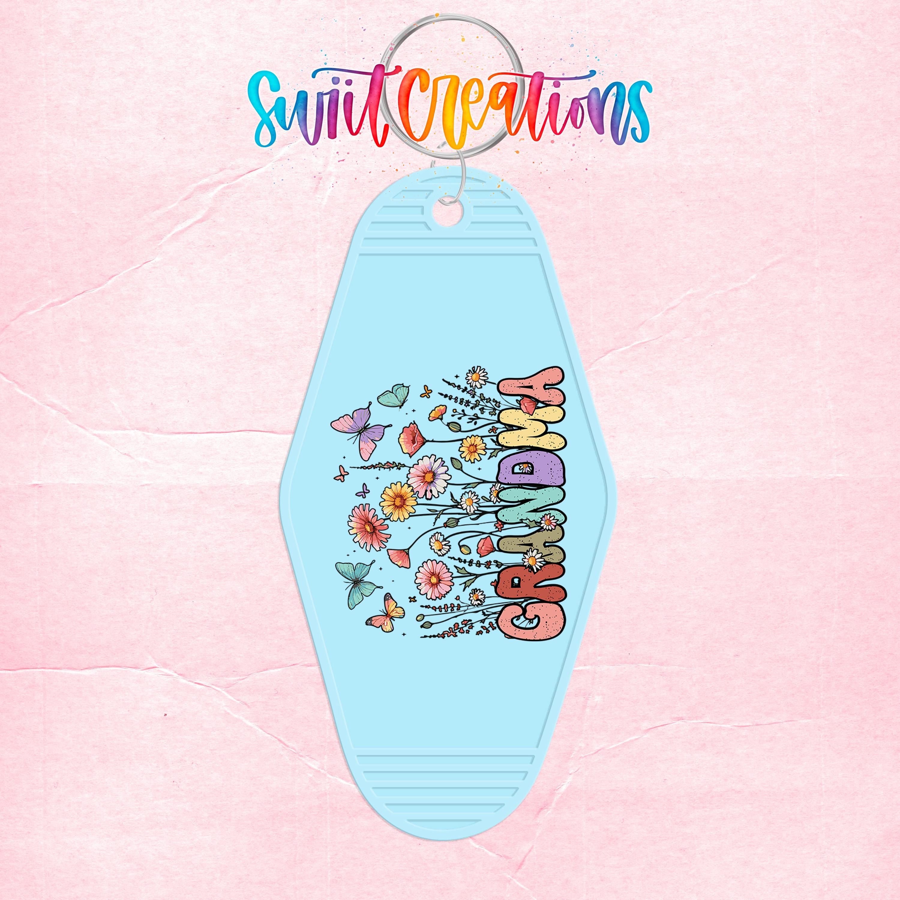 A keychain with a floral design and the word "GRANDMA" printed on it, set against a pink background.