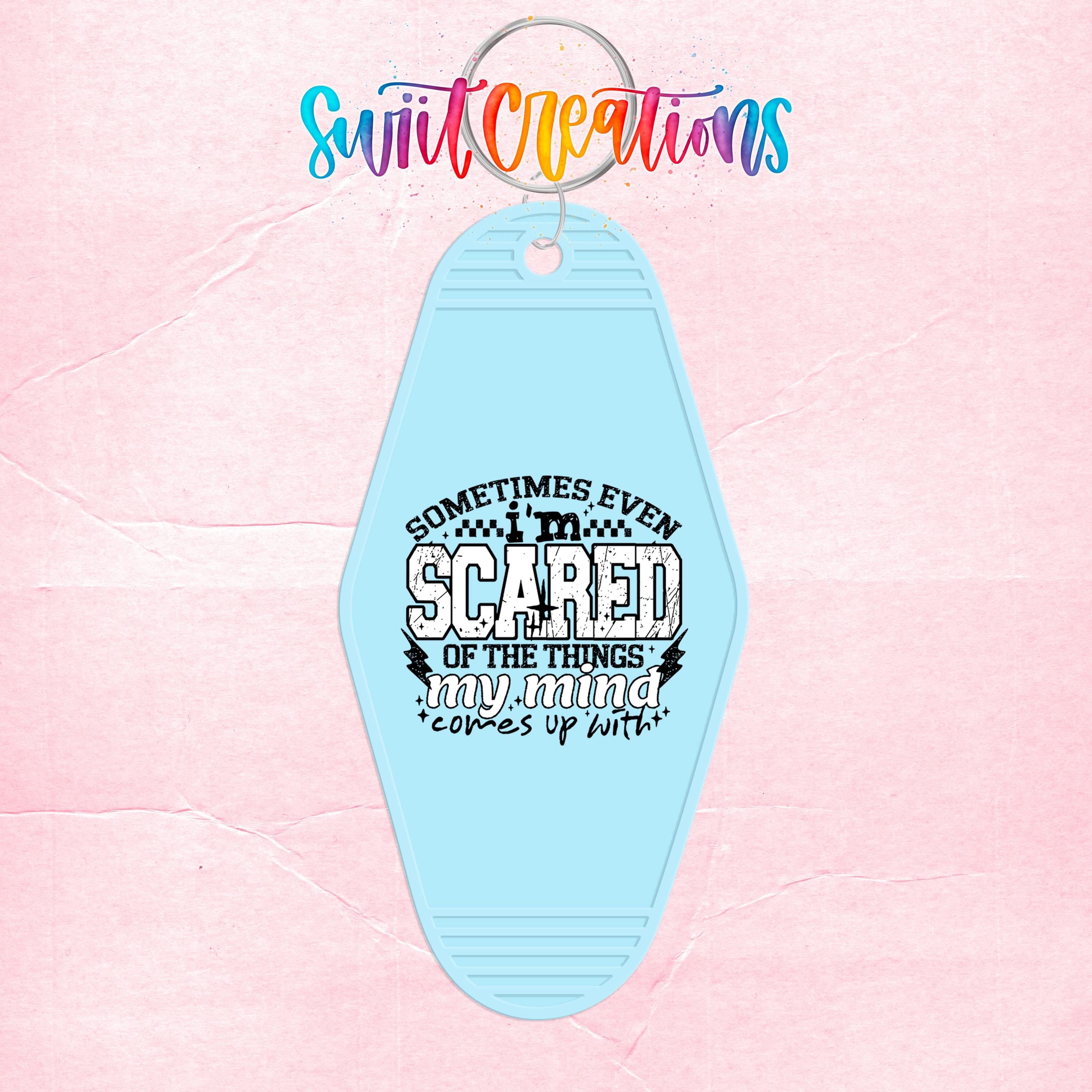 A light blue keychain with a printed message that says "Sometimes even scared of the things my mind talks about".