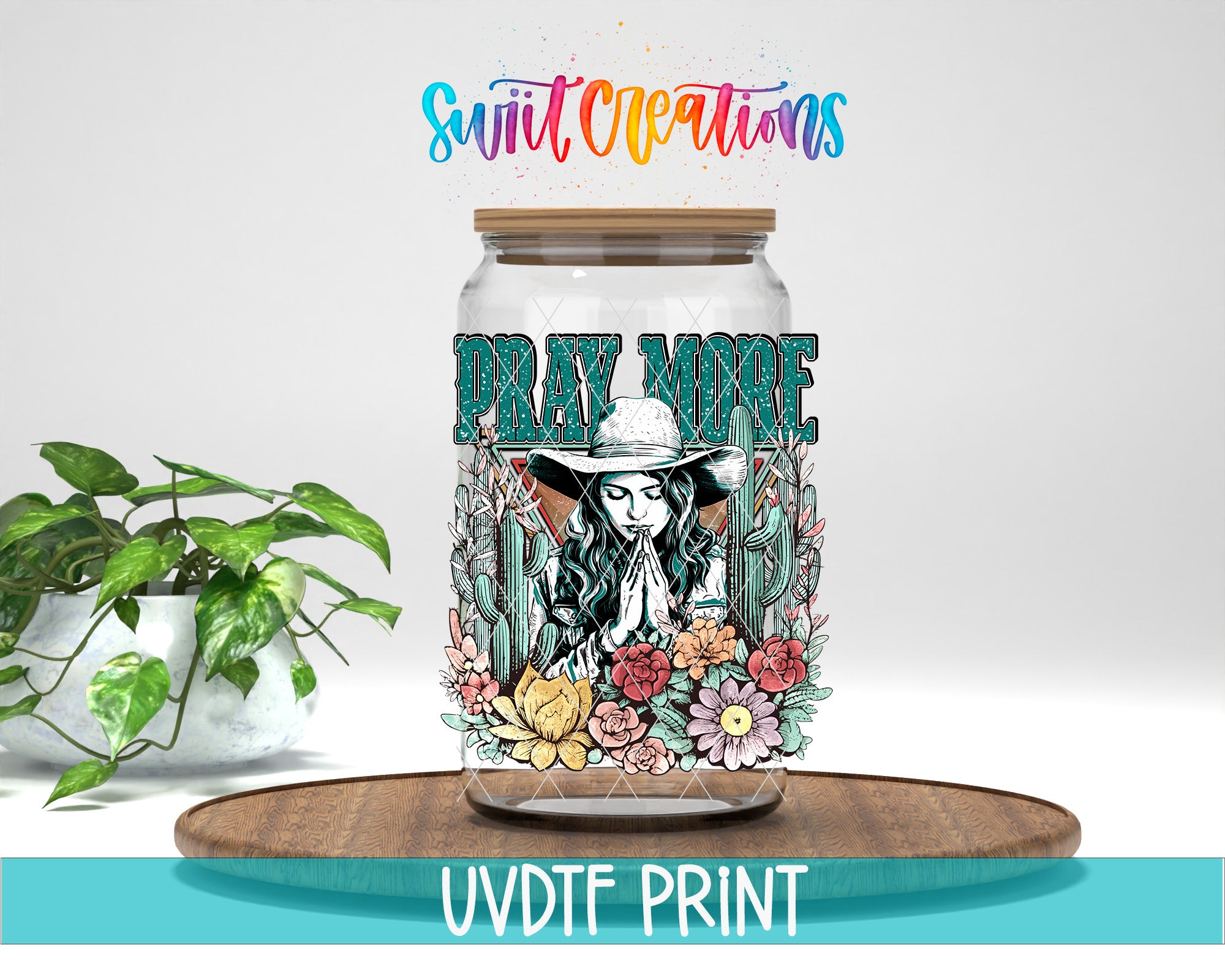 a glass jar with a colorful design, including a woman praying and flowers, placed on a wooden surface.