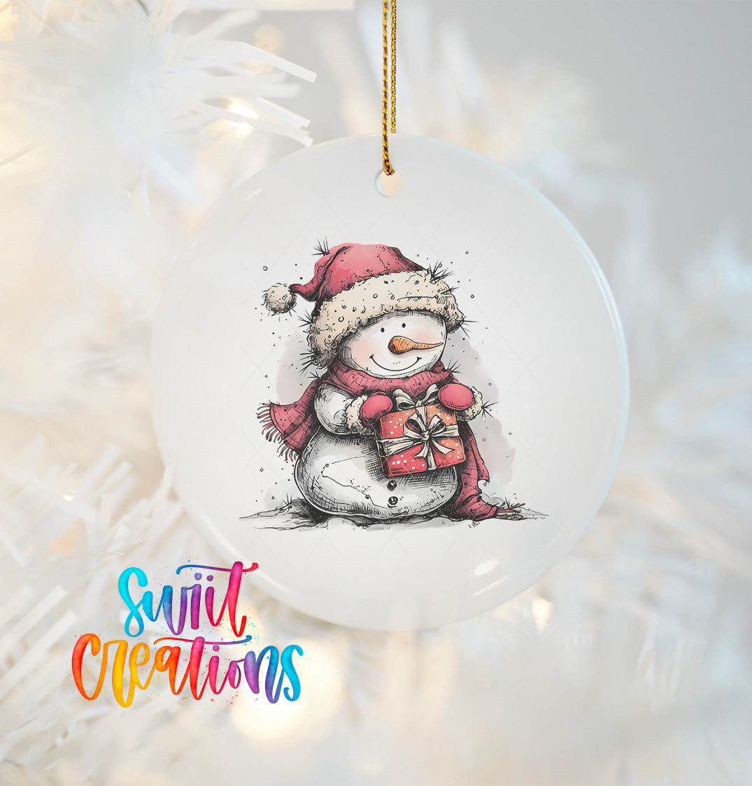 A white snowman ornament with a red scarf and a gift box, hanging on a Christmas tree.