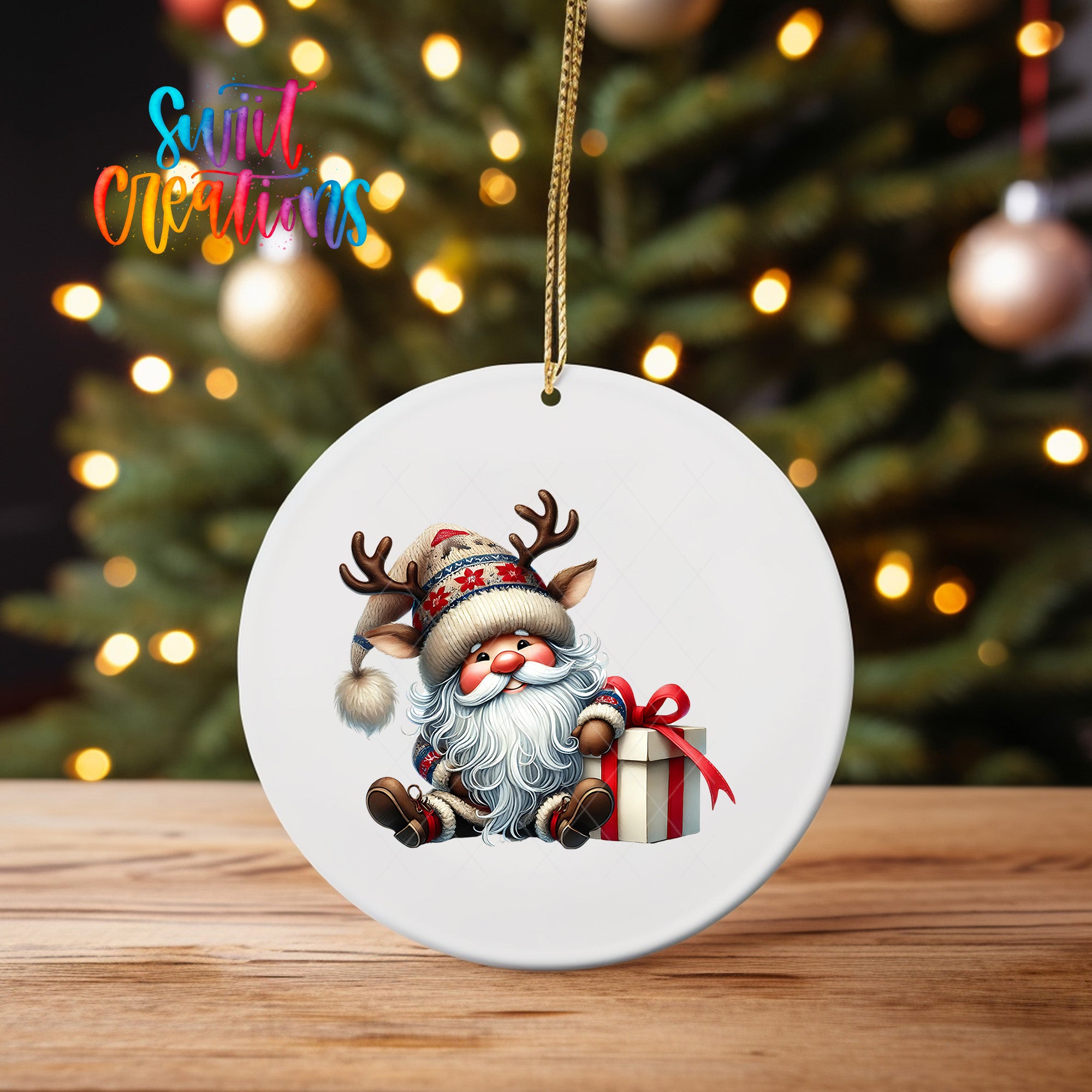A white ornament featuring a cartoon Santa Claus holding a gift box and wearing a hat with antlers, set against a blurred background of a Christmas tree with twinkling lights.