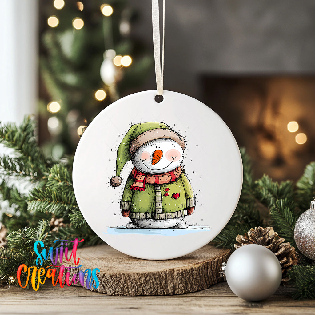 A white ceramic ornament featuring a snowman with a green hat and scarf, surrounded by Christmas decorations and greenery.