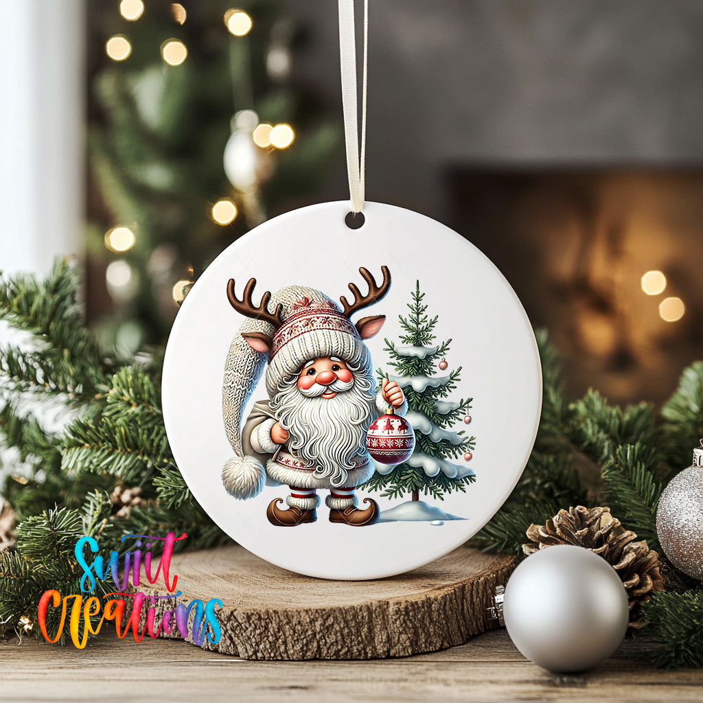 A white ceramic ornament featuring a cartoon Santa Claus holding a Christmas ornament and standing next to a pine tree, surrounded by holiday decorations such as ornaments and pine cones.