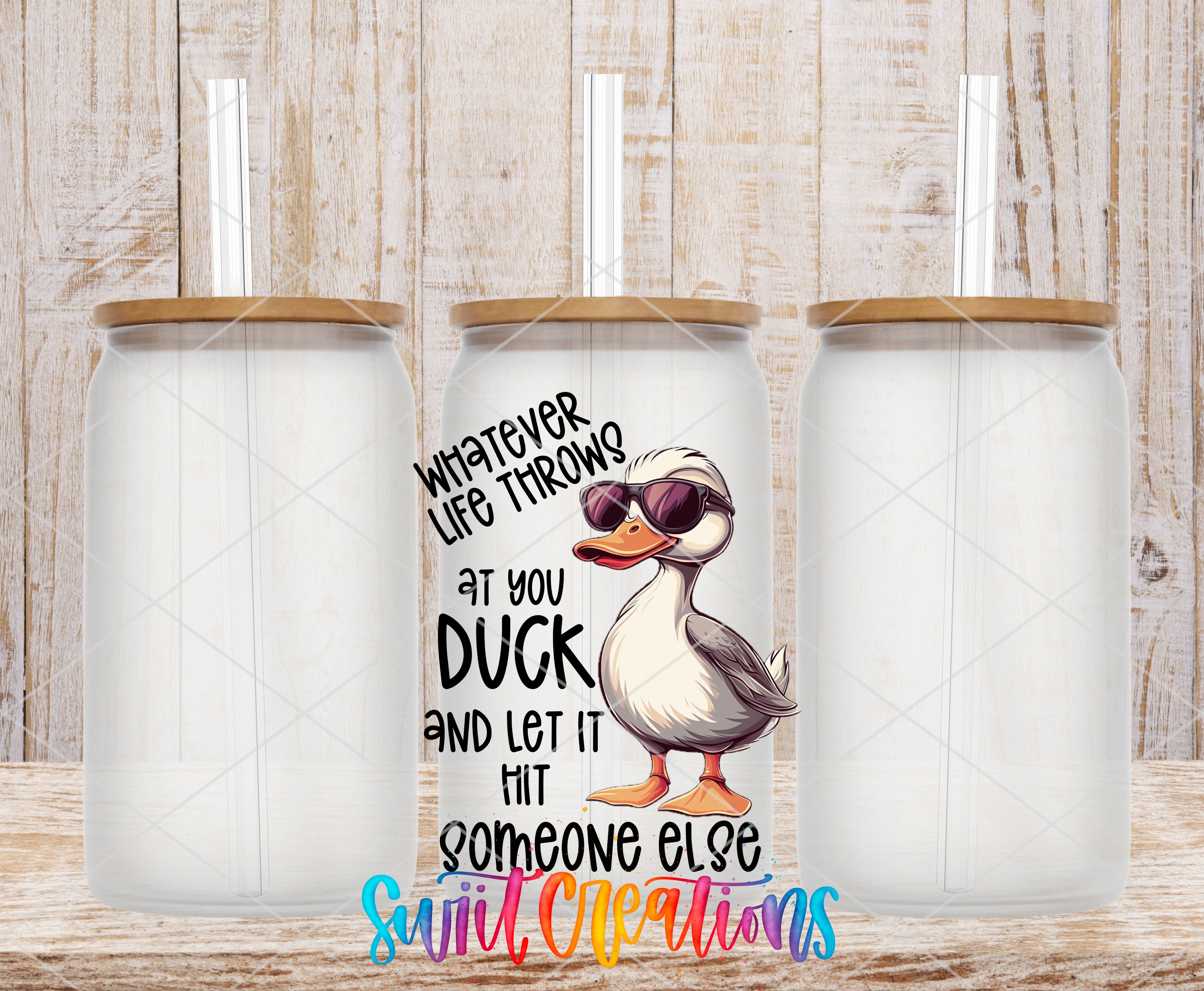 a clear glass jar with a cartoon duck on it, along with a straw. The jar has a label that says "Whatever life throws at you, duck and let it hit someone else".