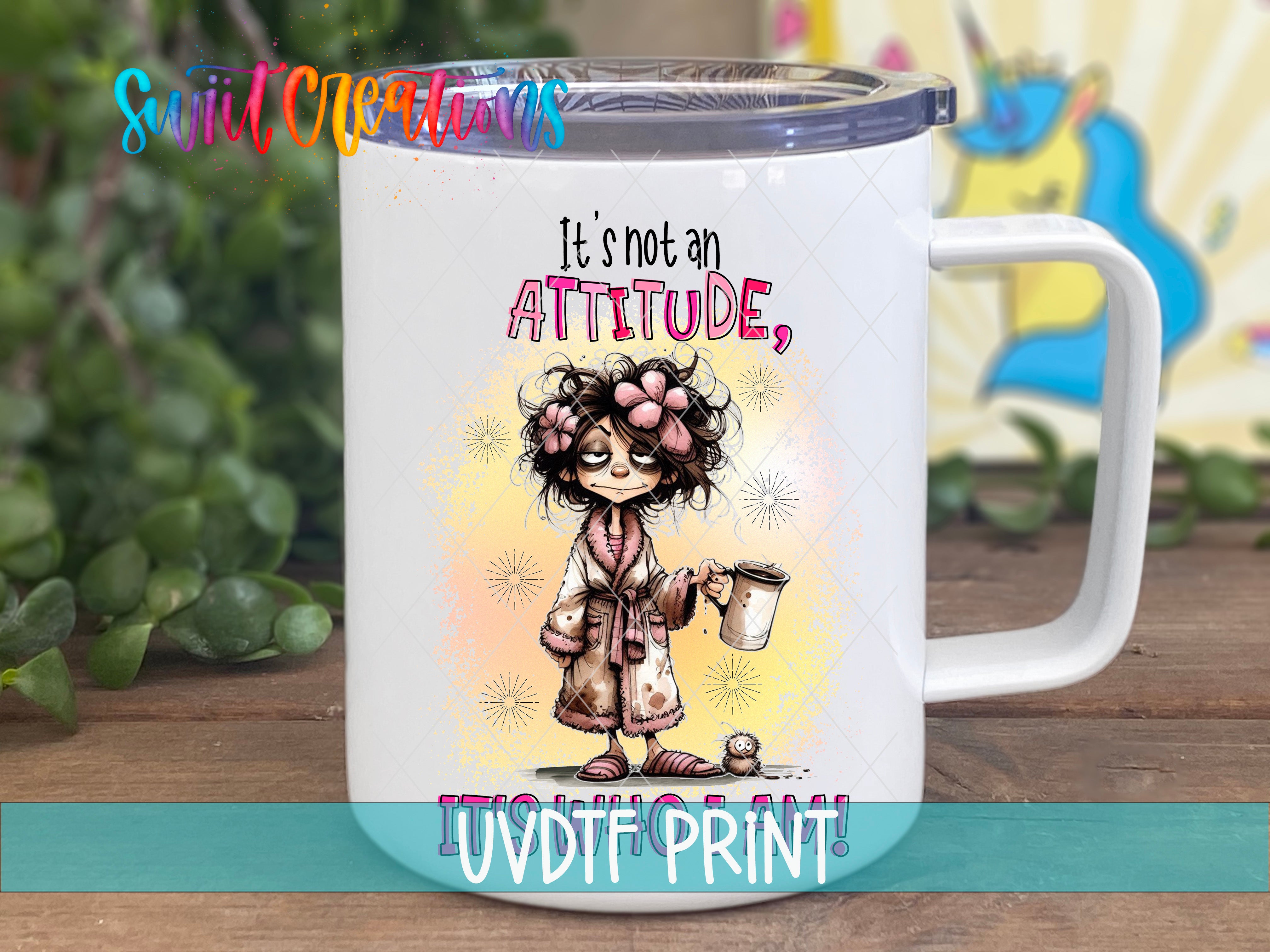 A white mug with a colorful illustration of a person wearing a bathrobe and holding a cup, along with the text "It's not an ATTITUDE, IT'S A PRINT!"