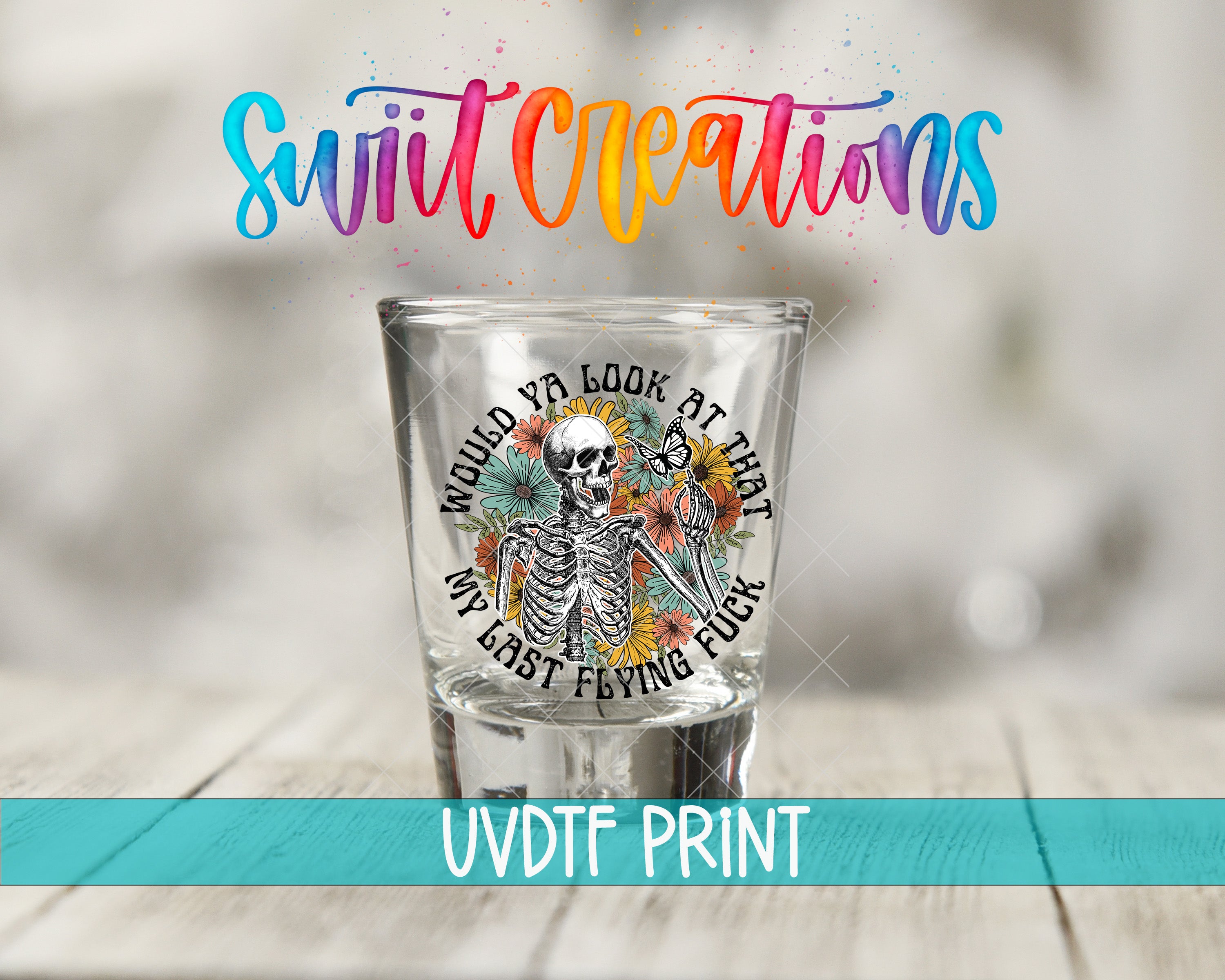 A shot glass with a skeleton design and colorful text, along with the text "Swift Creations" and "UVDF PRINT" printed on it.