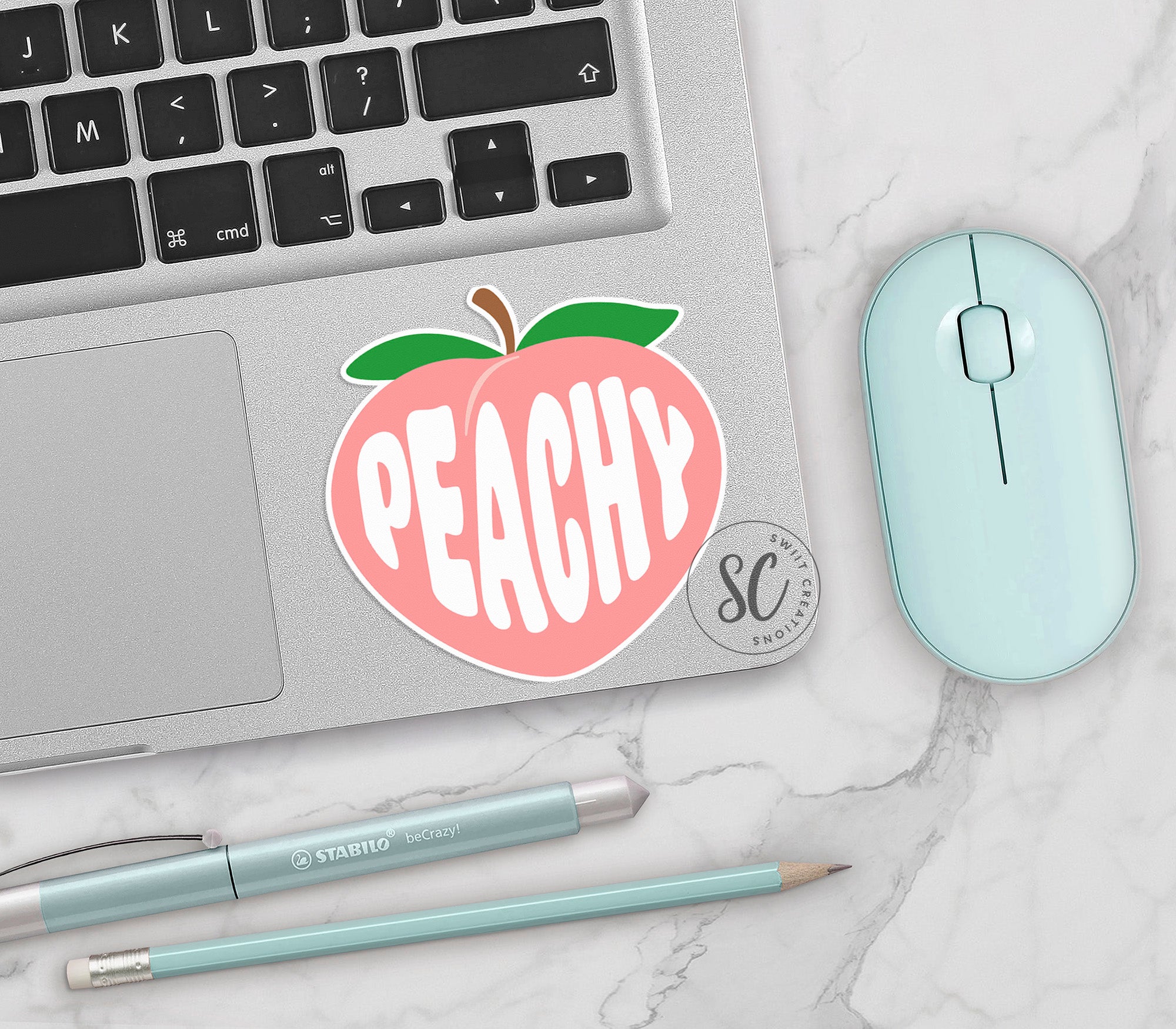 an apple sticker on a laptop next to a mouse