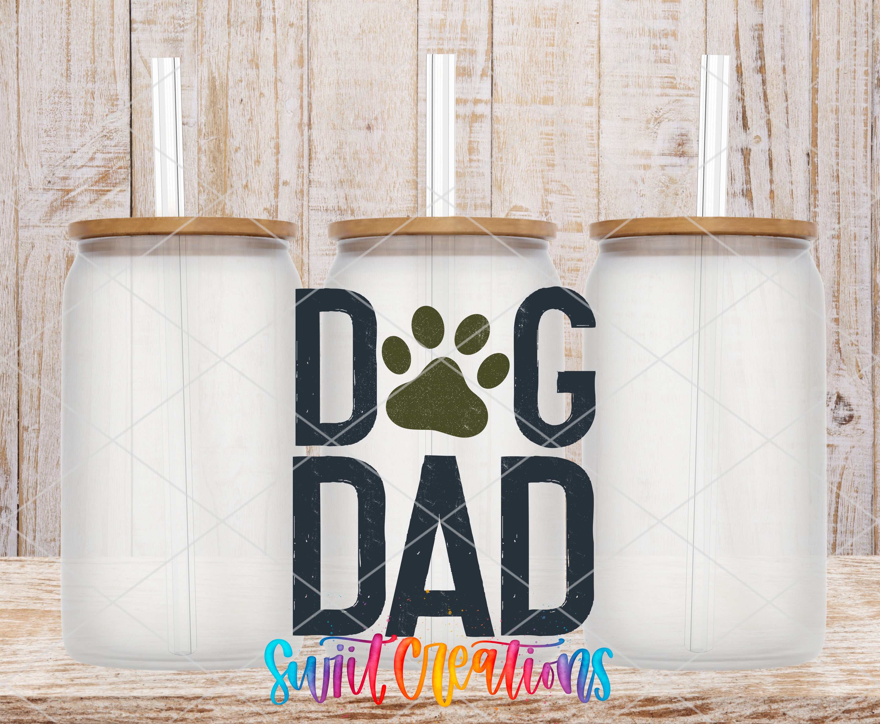 Three clear glass cans with the Dog Dad Paw Print UV DTF transfer by Swiit Creations