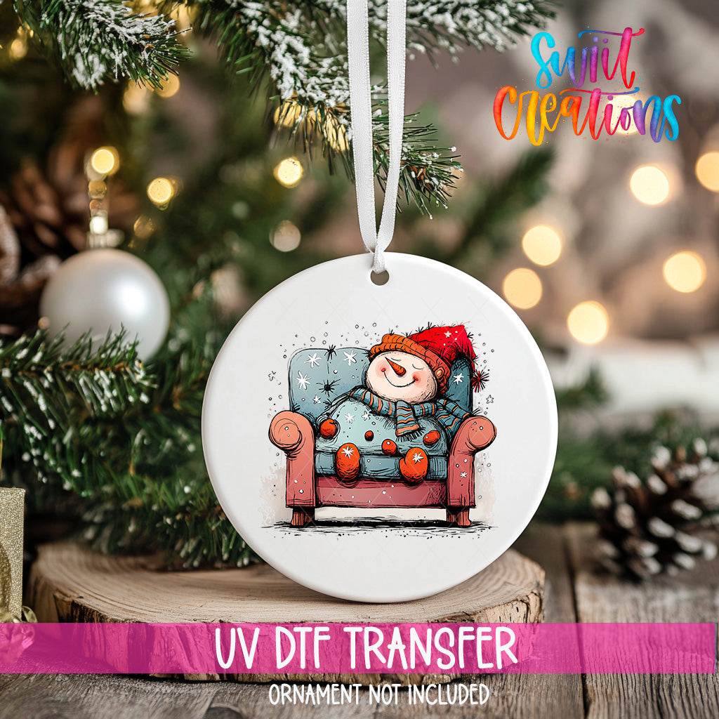 A white ceramic ornament with a snowman sitting in a chair, surrounded by Christmas decorations and lights.
