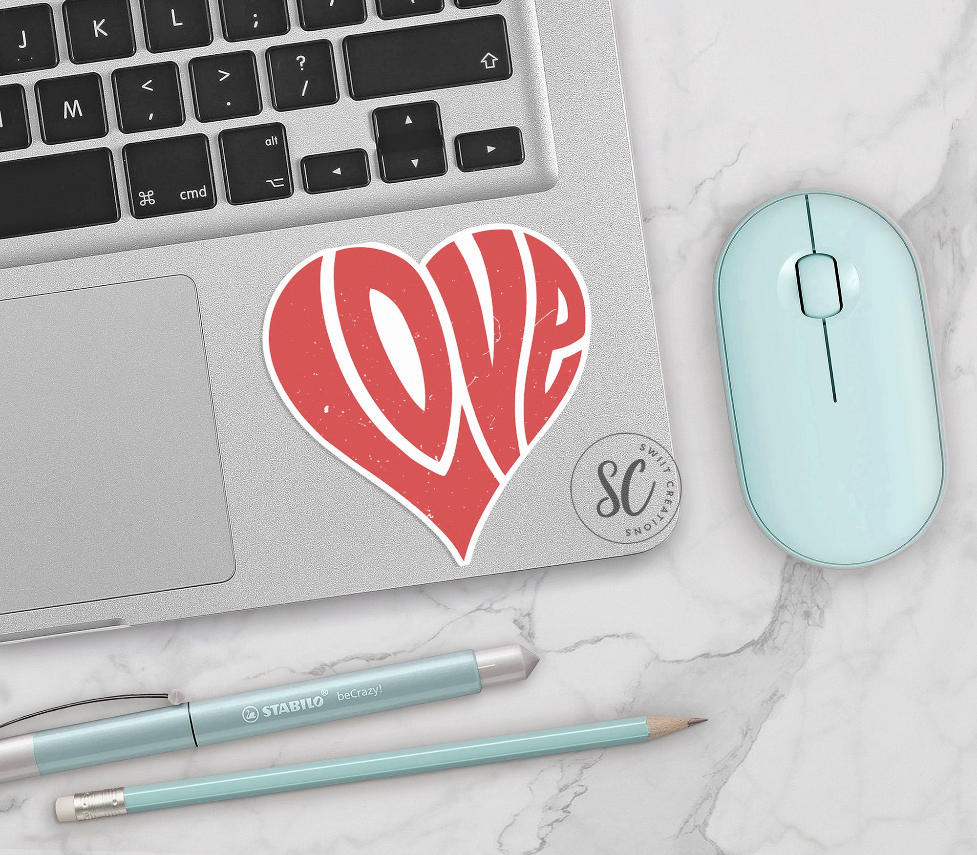 a laptop with a sticker of a heart on it