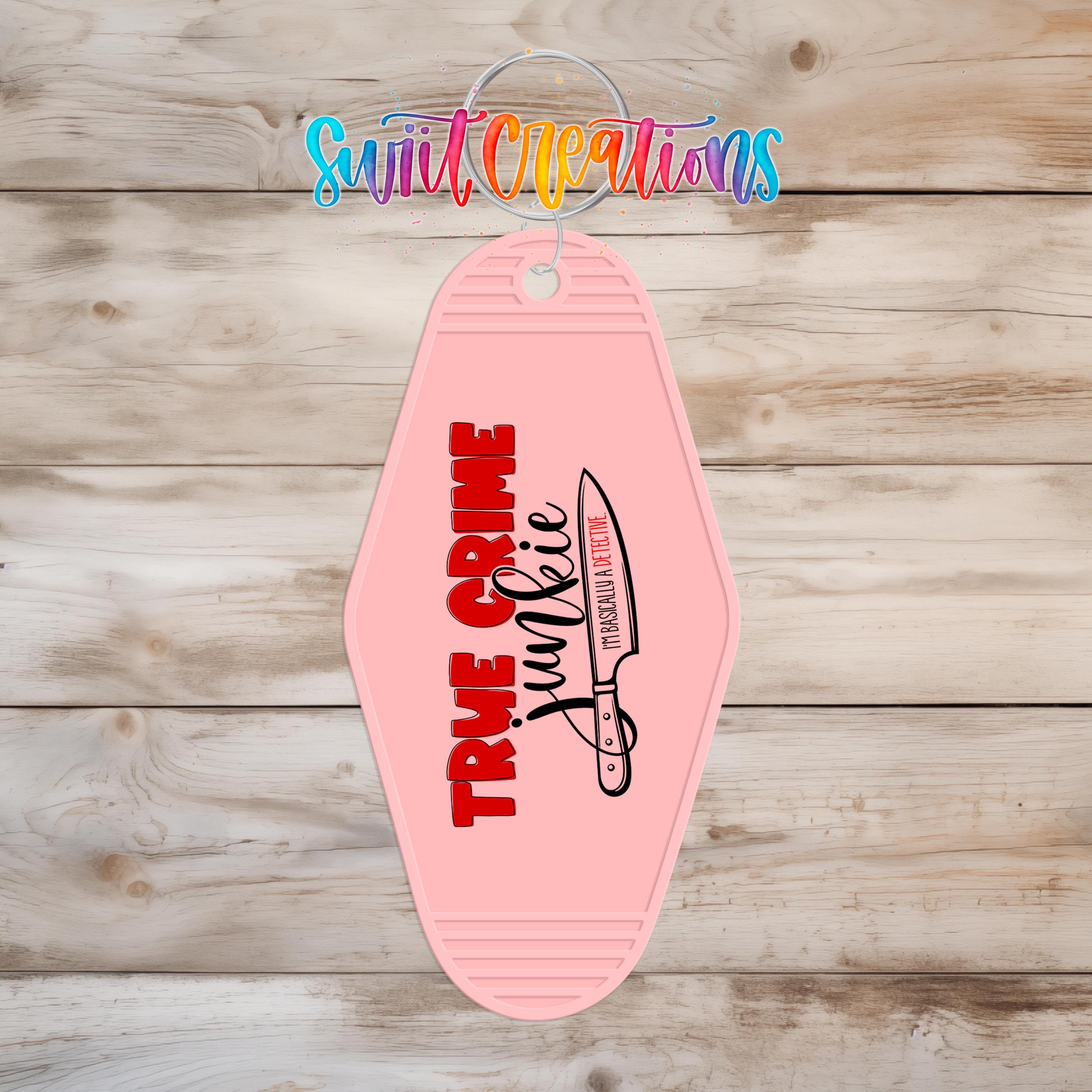 A pink keychain with the text "TRUE CRIME JUNKIE" printed on it, along with a graphic of a knife.