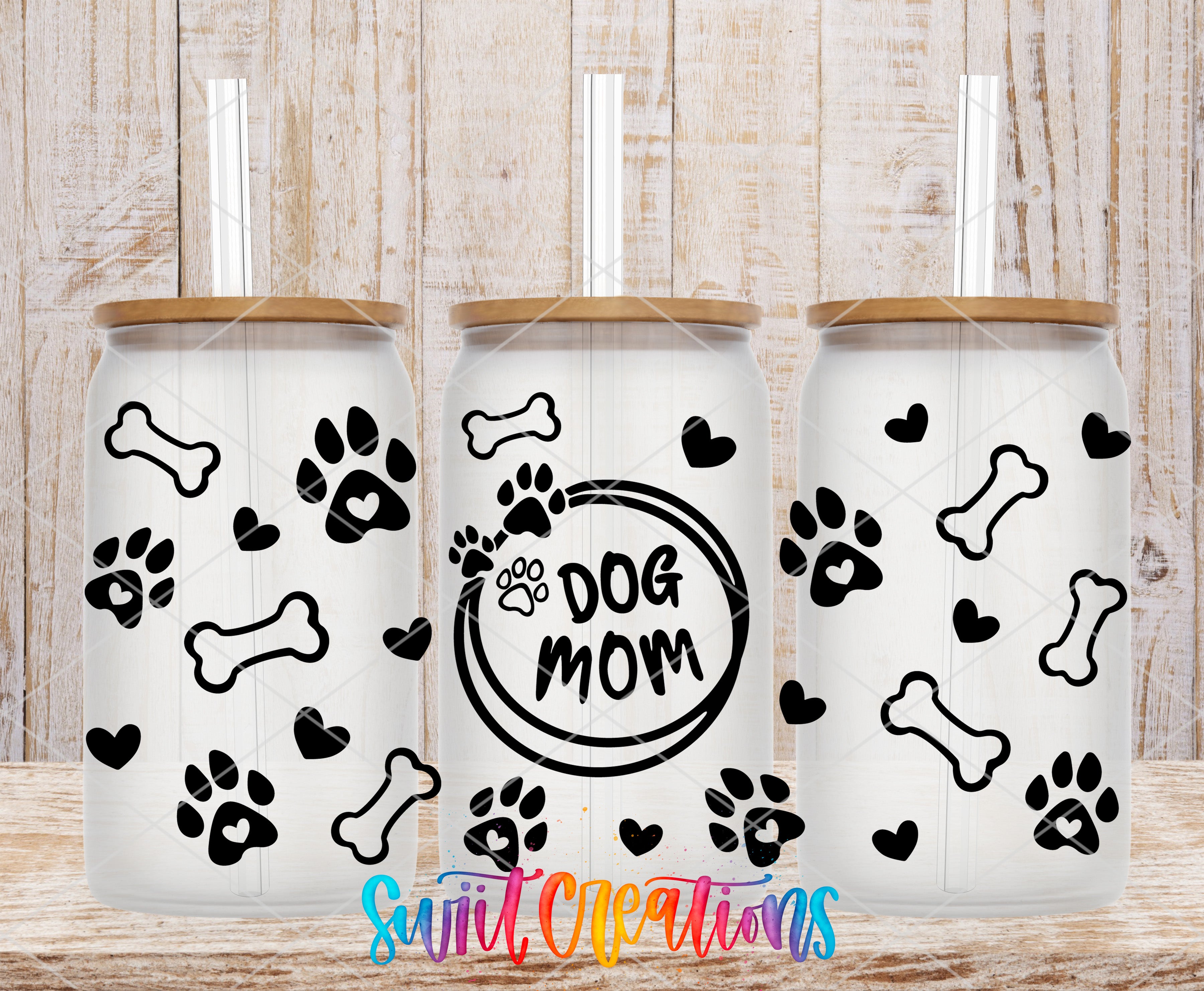 three white tumblers with black paw prints and heart designs, along with the text "Dog Mom" printed on them.
