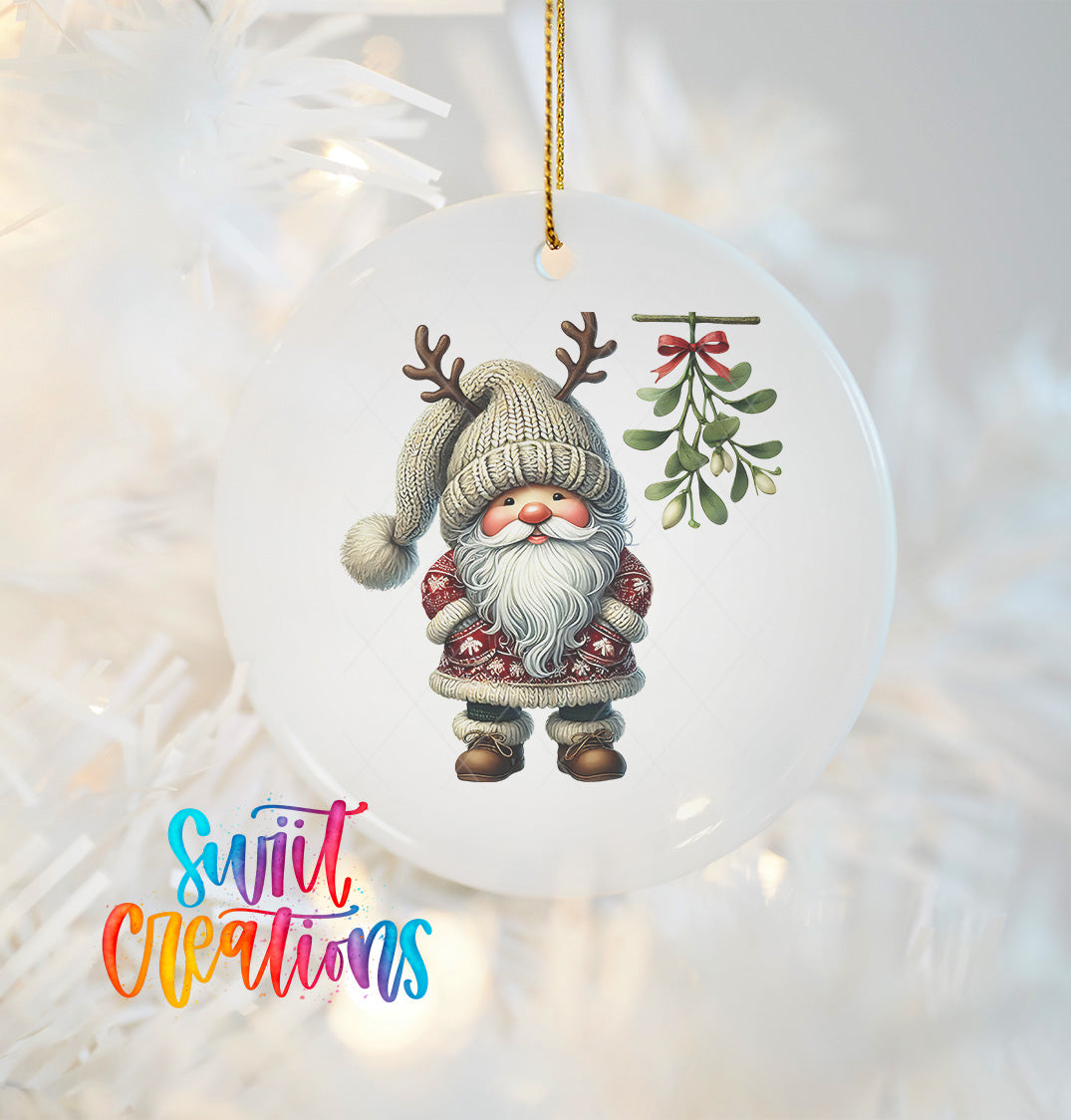 A white ornament featuring a gnome with antlers and a mistletoe, hanging on a Christmas tree.