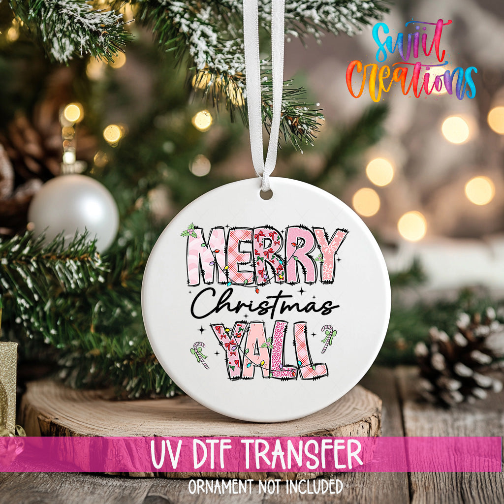 A white Christmas ornament with the text "Merry Christmas YALL" printed on it, hanging on a Christmas tree.