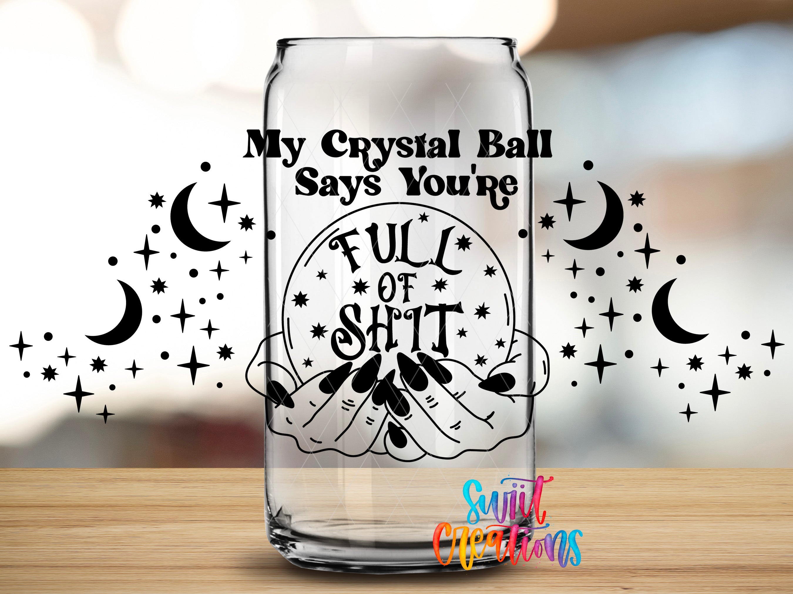 a glass with a humorous text and graphics design on it, including a crystal ball and stars.